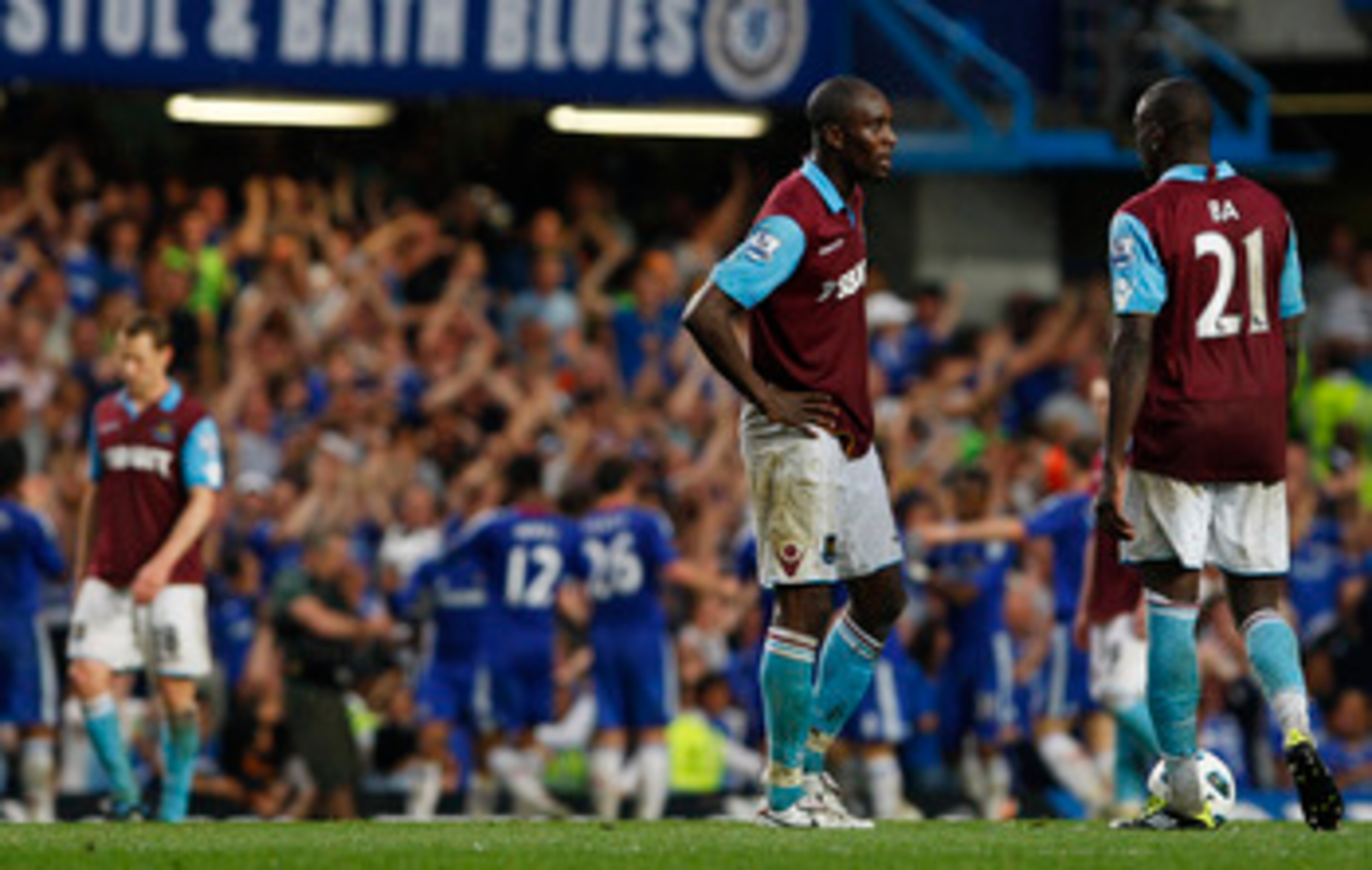 LONDON, ENGLAND - APRIL 23:  Demba Ba (R) and Carlton Cole of West Ham show their dejection as Chelsea players celebrate team mate Frank Lampard's opening goal during the Barclays Premier League match between Chelsea and West Ham United at Stamford Bridge