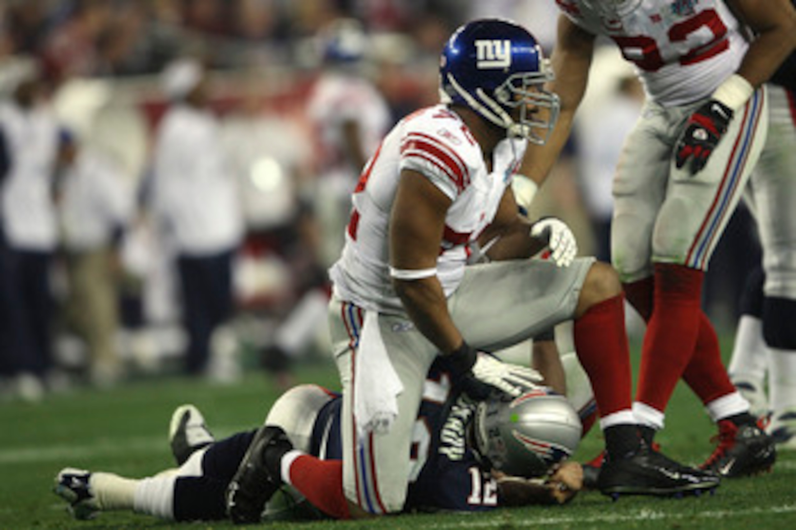 GLENDALE, AZ - FEBRUARY 03:  Defensive end Osi Umenyiora #72 of the New York Giants sits on Tom Brady #12 of the New England Patriots in the second quarter of Super Bowl XLII on February 3, 2008 at the University of Phoenix Stadium in Glendale, Arizona.