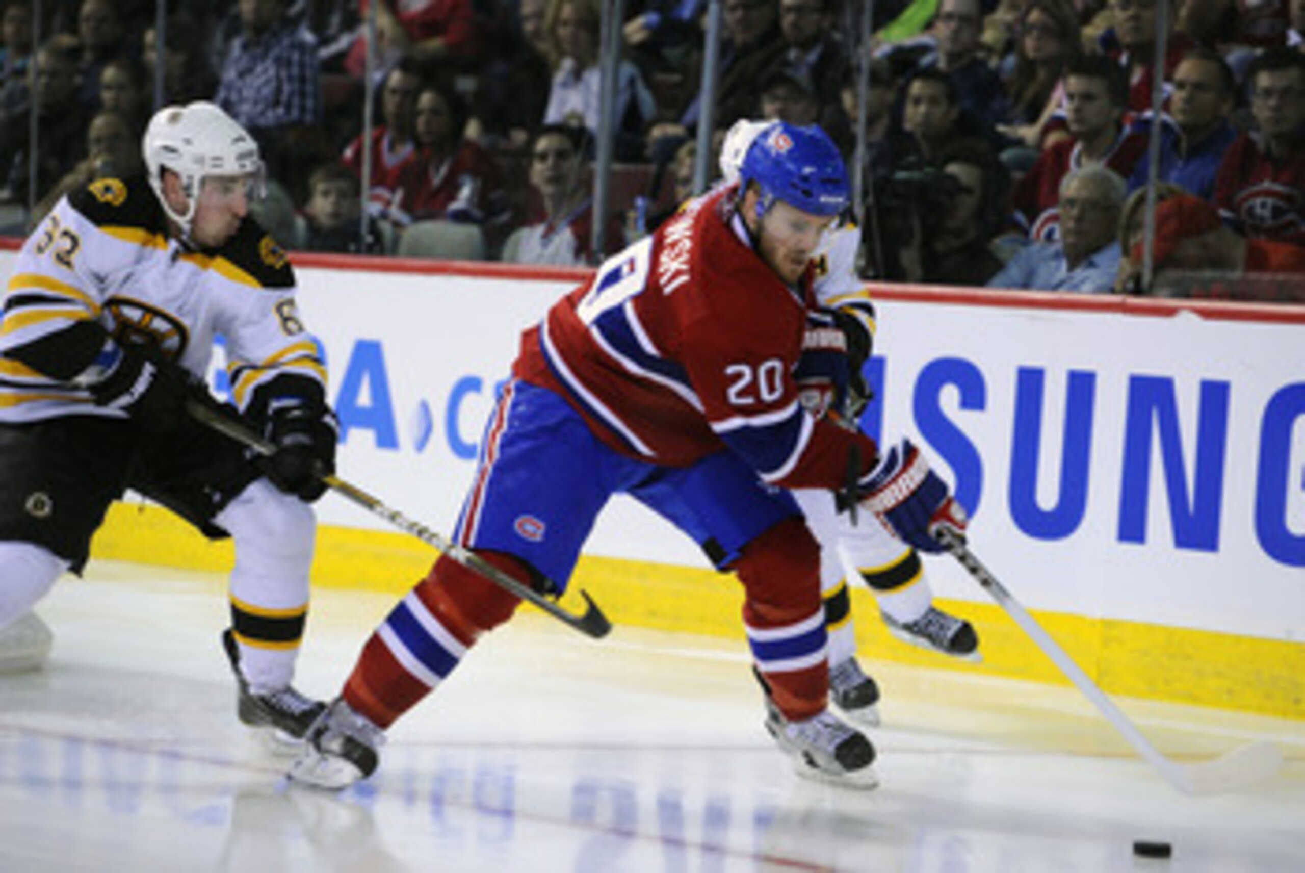 MONTREAL, QC - APRIL 21:  James Wisniewski #20 of the Montreal Canadiens tries to clear the puck off the boards while being pursued by Brad Marchand #63 and Patrice Bergeron #37 of the Boston Bruins in Game Four of the Eastern Conference Quarterfinals dur
