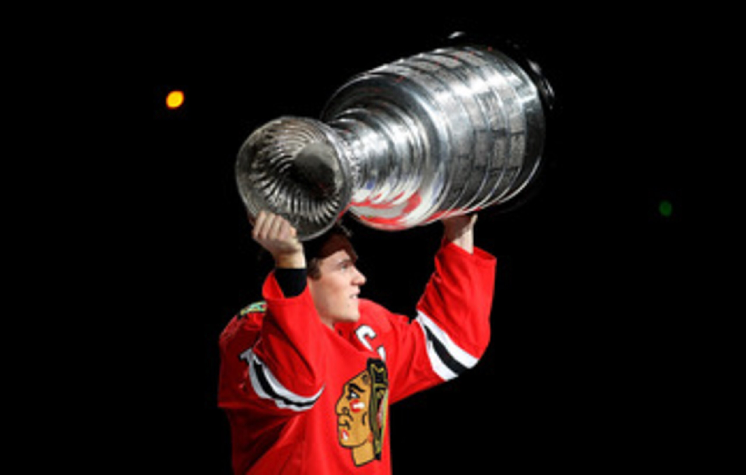 CHICAGO - OCTOBER 09: Jonathan Toews #19 of the Chicago Blackhawks carries the Stanley Cup trophy across the ice in a ceremony before the Blackhawks season home opening game against the Detroit Red Wings at the United Center on October 9, 2010 in Chicago,