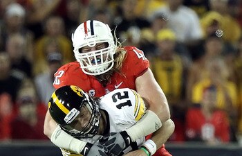 TUCSON, AZ - SEPTEMBER 18:  Quarterback Ricky Stanzi #12 of the Iowa Hawkeyes is sacked by Brooks Reed #42 of the Arizona Wildcats during the third quarter of the college football game at Arizona Stadium on September 18, 2010 in Tucson, Arizona.  The Wild