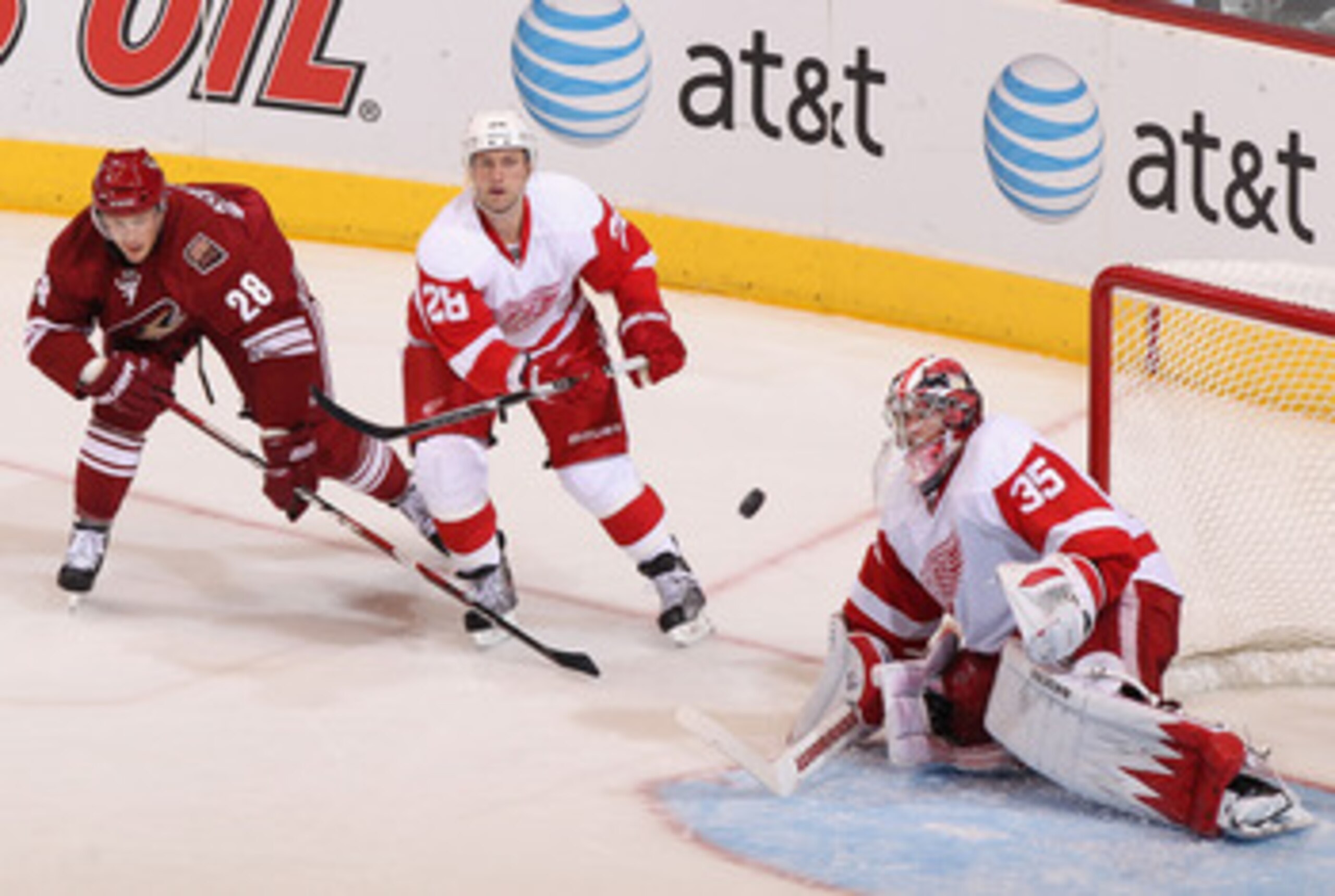 GLENDALE, AZ - APRIL 20:  Brian Rafalski #28 of the Detroit Red Wings clears the puck past goaltender Jimmy Howard #35 while pressed from Lauri Korpikoski #28 of the Phoenix Coyotes in Game Four of the Western Conference Quarterfinals during the 2011 NHL 