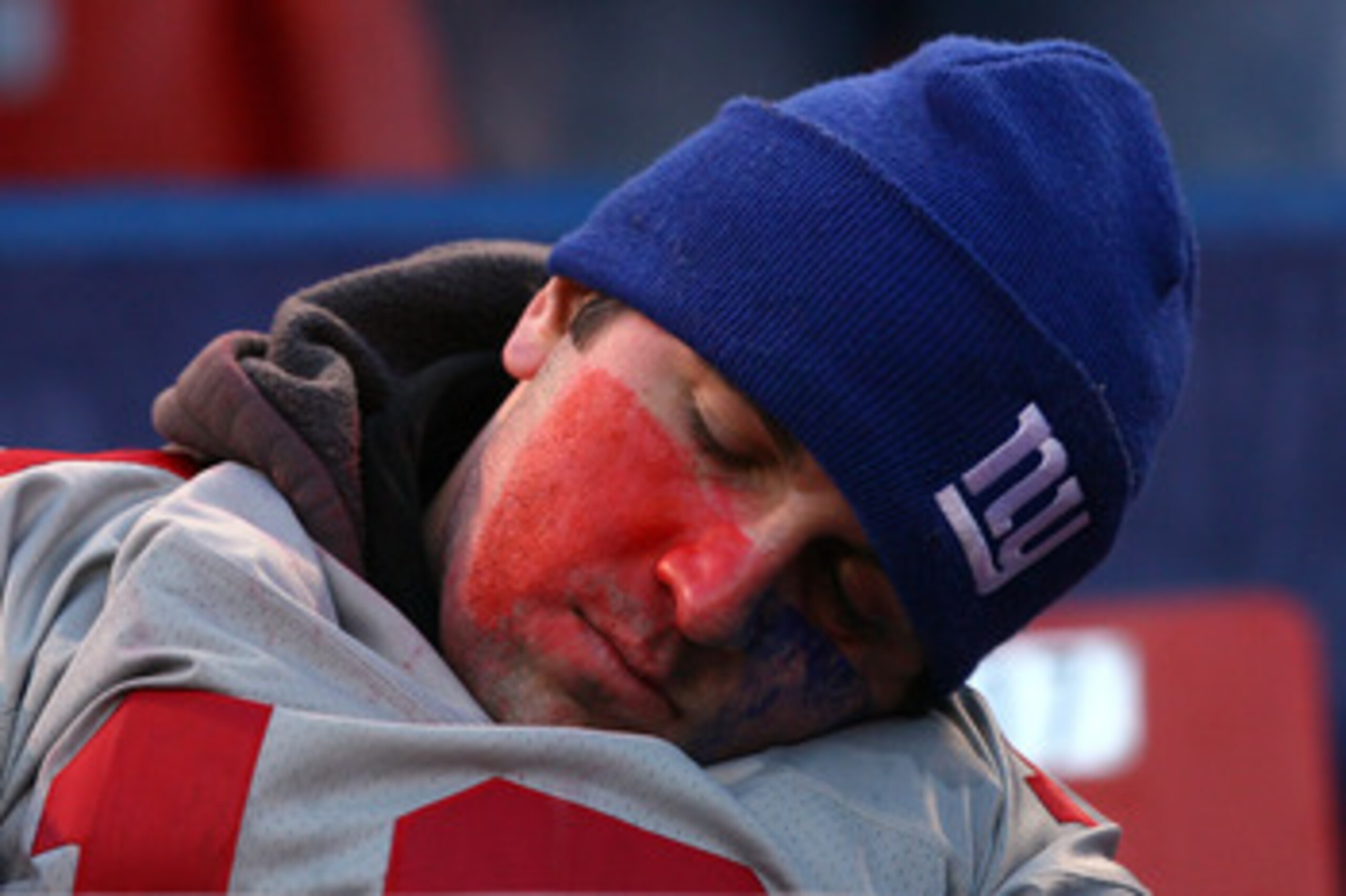 EAST RUTHERFORD, NJ - JANUARY 11: A fan of the New York Giants sleeps during a game against the Philadelphia Eagles during the NFC Divisional Playoff Game on January 11, 2009 at Giants Stadium in East Rutherford, New Jersey.The Eagles won the game by a s EAST RUTHERFORD, NJ - JANUARY 11: A fan of the New York Giants sleeps during a game against the Philadelphia Eagles during the NFC Divisional Playoff Game on January 11, 2009 at Giants Stadium in East Rutherford, New Jersey.The Eagles won the game by a s