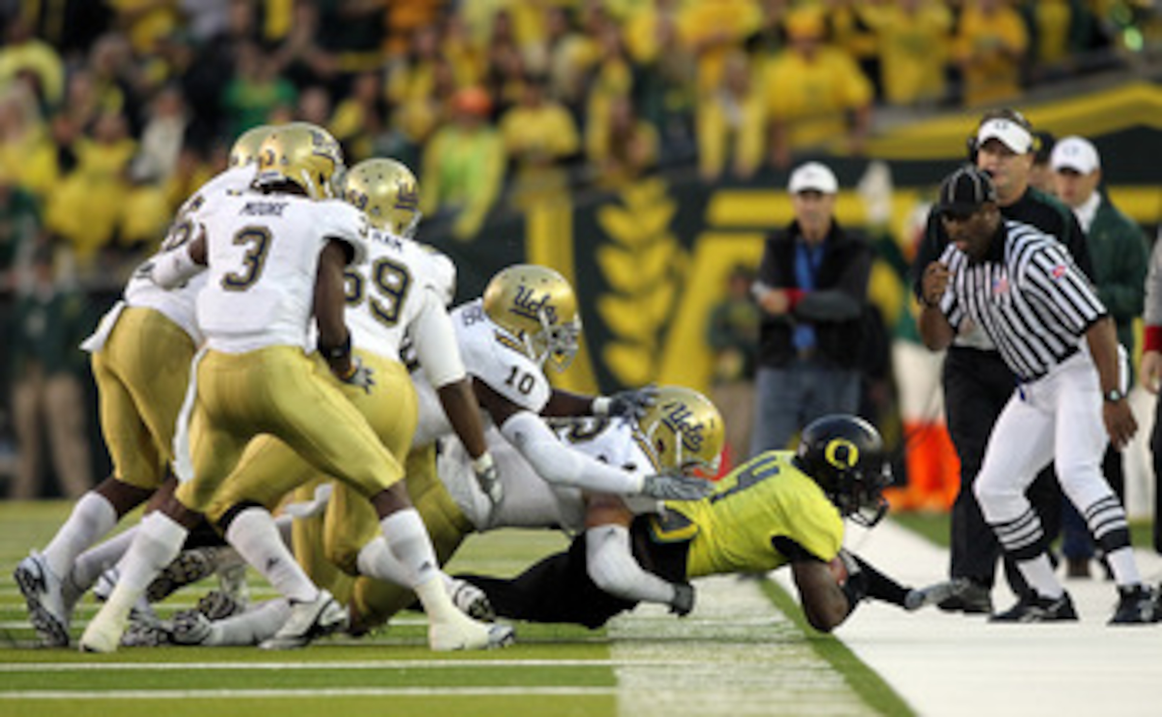 EUGENE, OR - OCTOBER 21:  Josh Huff #4 of the Oregon Ducks is tackled by defenders of the UCLA Bruins  on October 21, 2010 at the Autzen Stadium in Eugene, Oregon.  (Photo by Jonathan Ferrey/Getty Images)