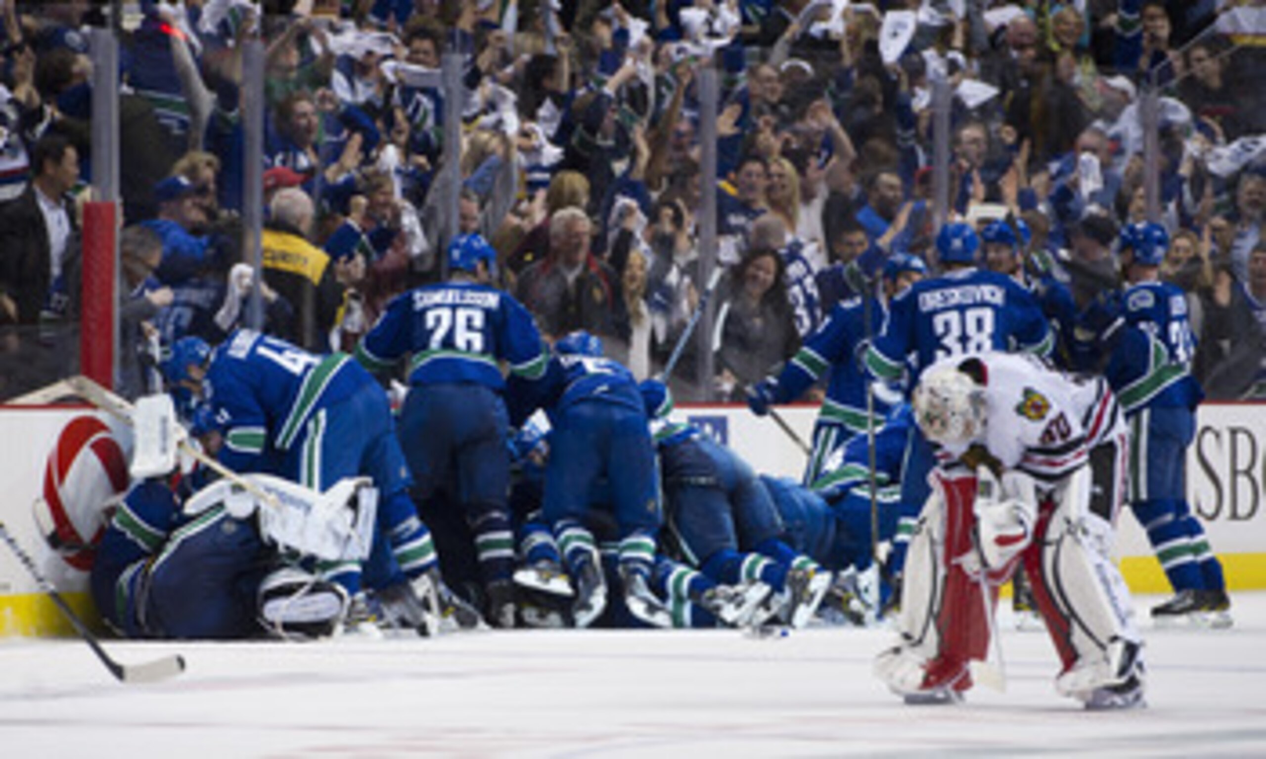 VANCOUVER, CANADA - APRIL 26: The Vancouver Canucks celebrate after defeating the Chicago Blackhawks 2-1 in overtime as goalie Corey Crawford #50 Chicago Blackhawks skates back to his after Game Seven of the Western Conference Quarterfinals during the 201 VANCOUVER, CANADA - APRIL 26: The Vancouver Canucks celebrate after defeating the Chicago Blackhawks 2-1 in overtime as goalie Corey Crawford #50 Chicago Blackhawks skates back to his after Game Seven of the Western Conference Quarterfinals during the 201