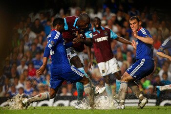 LONDON, ENGLAND - APRIL 23:  Carlton Cole (C) of West Ham shoots in between John Obi Mikel (L) and Branislav Ivanovic of Chelsea during the Barclays Premier League match between Chelsea and West Ham United at Stamford Bridge on April 23, 2011 in London, E
