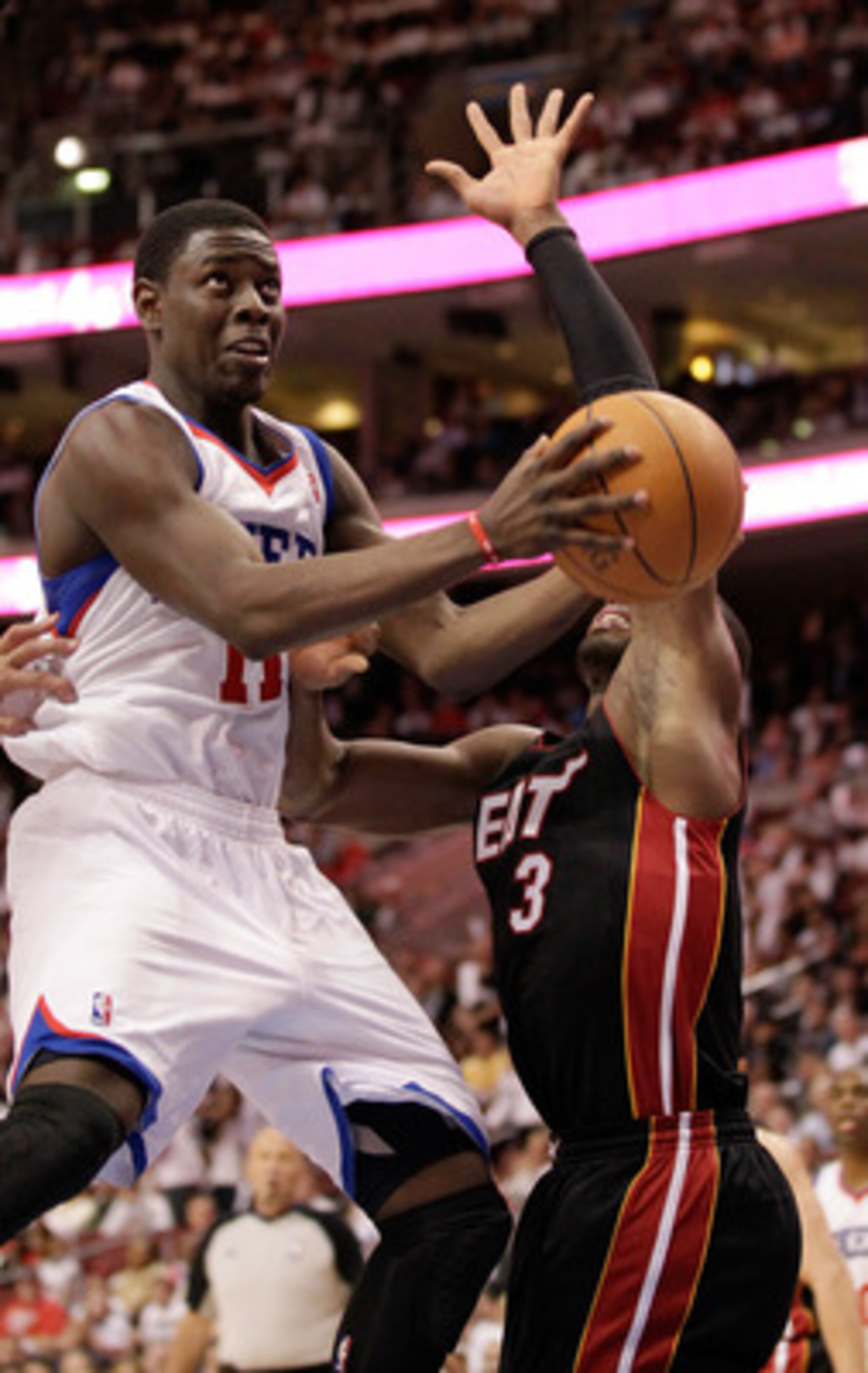 PHILADELPHIA, PA - APRIL 21: Jrue Holiday #11 of the Philadelphia 76ers drives to the basket while being guarded by Dwyane Wade #3 of the Miami Heat in Game Three of the Eastern Conference Quarterfinals during the 2011 NBA Playoffs at Wells Fargo Center o