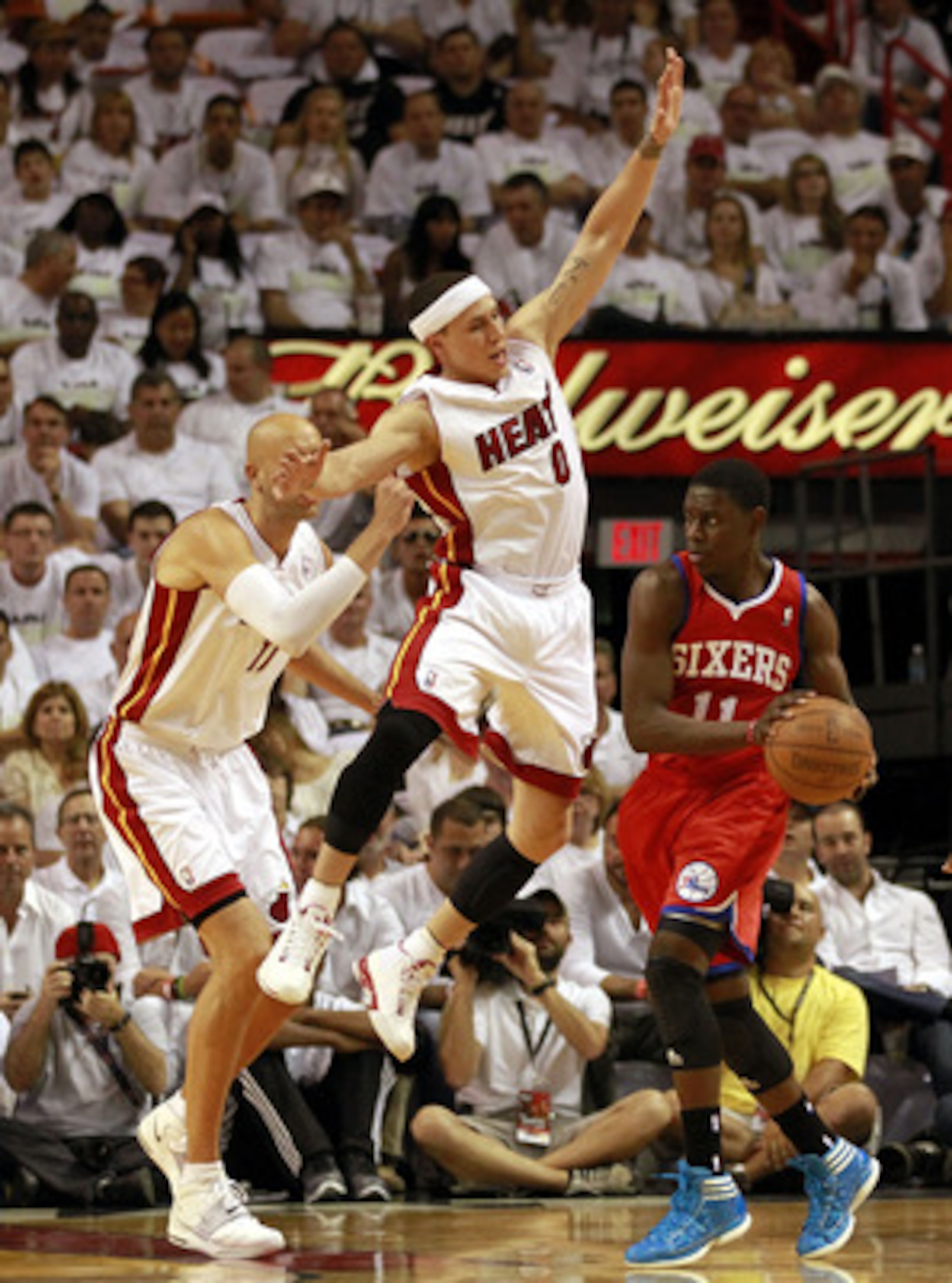 MIAMI, FL - APRIL 16:  Guard Jrue Holiday #11 of the Philadelphia 76ers drives against Center Zydrunas ilgauskas #11 amd guard Mike Bibby #0 of the Maim Heat at the American Airlines Arena in Game One of the Eastern Conference Quarterfinals in the 2011 NB
