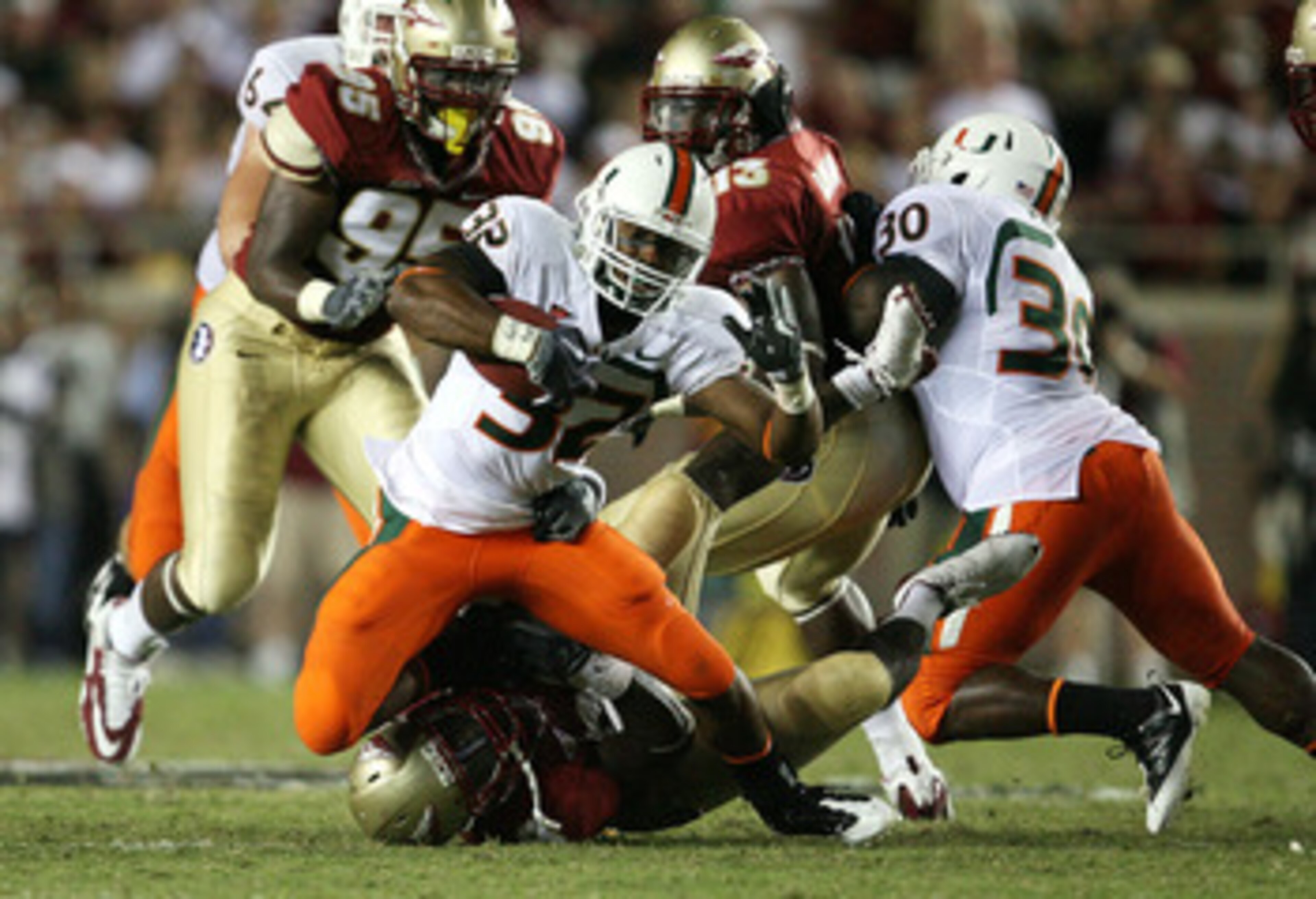 TALLAHASSEE, FL - SEPTEMBER 07:  Running back Lee Chambers #32 of the Miami Hurricanes dives for extra yards as he is brought down against the Florida State Seminoles at Doak Campbell Stadium on September 7, 2009 in Tallahassee, Florida.  (Photo by Doug B