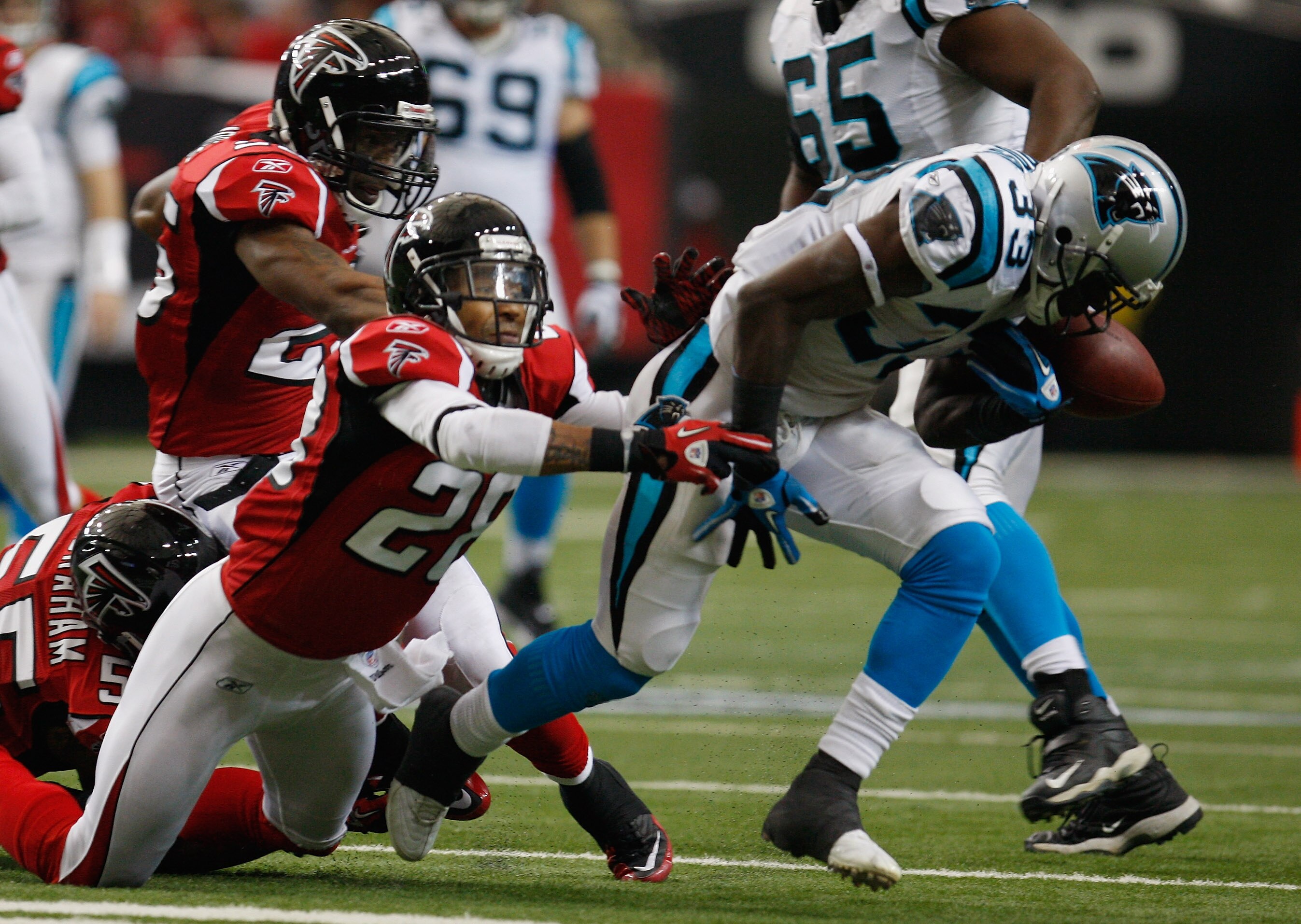ATLANTA, GA - JANUARY 02:  Mike Goodson#33 of the Carolina Panthers loses a fumble in the second quarter after being hit by Thomas DeCoud #28 of the Atlanta Falcons at the Georgia Dome on January 2, 2011 in Atlanta, Georgia.  (Photo by Scott Halleran/Gett