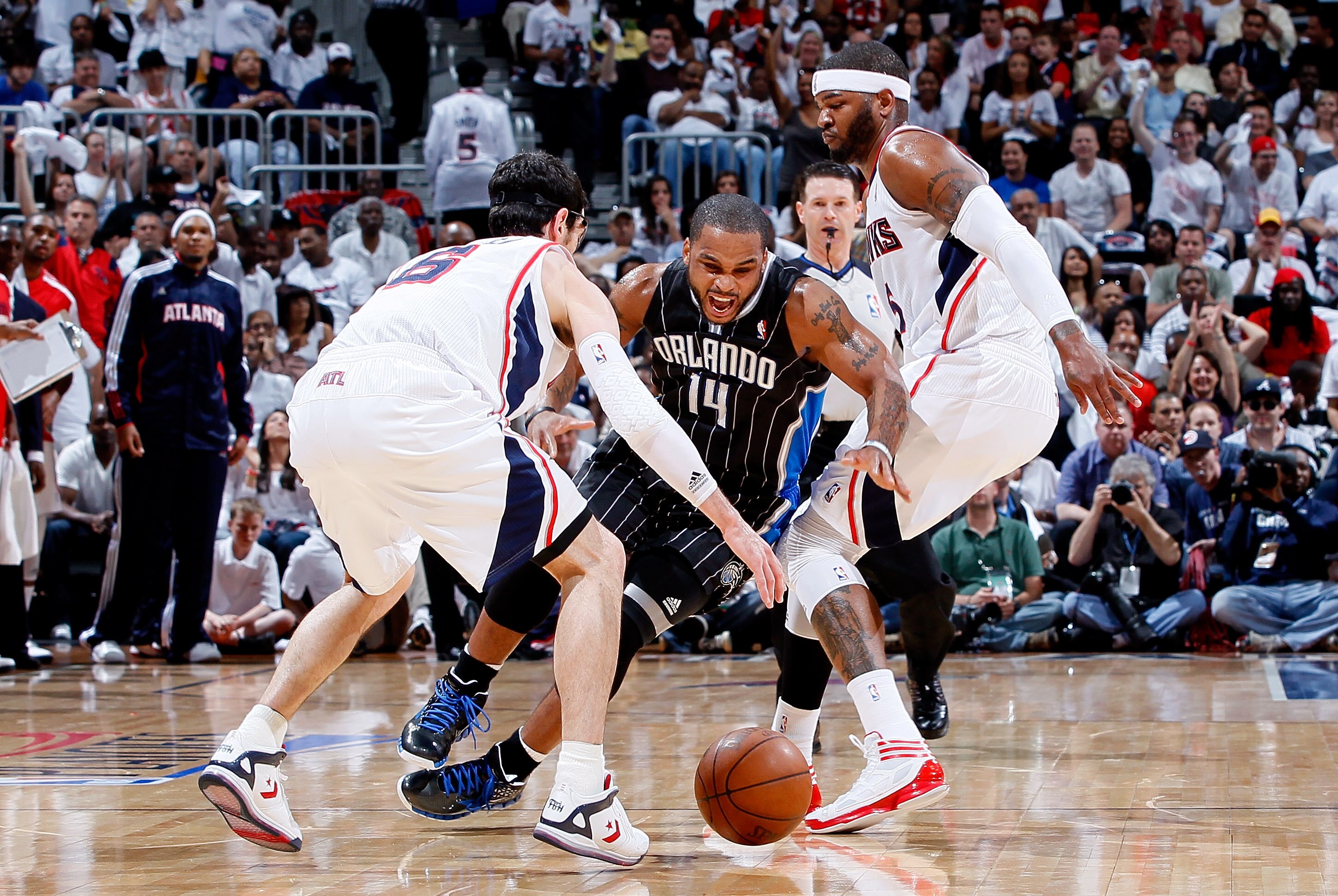 ATLANTA, GA - APRIL 24:  Jameer Nelson #14 of the Orlando Magic loses the ball as he dribbles between Kirk Hinrich #6 and Josh Smith #5 of the Atlanta Hawks during Game Four of the Eastern Conference Quarterfinals in the 2011 NBA Playoffs at Philips Arena