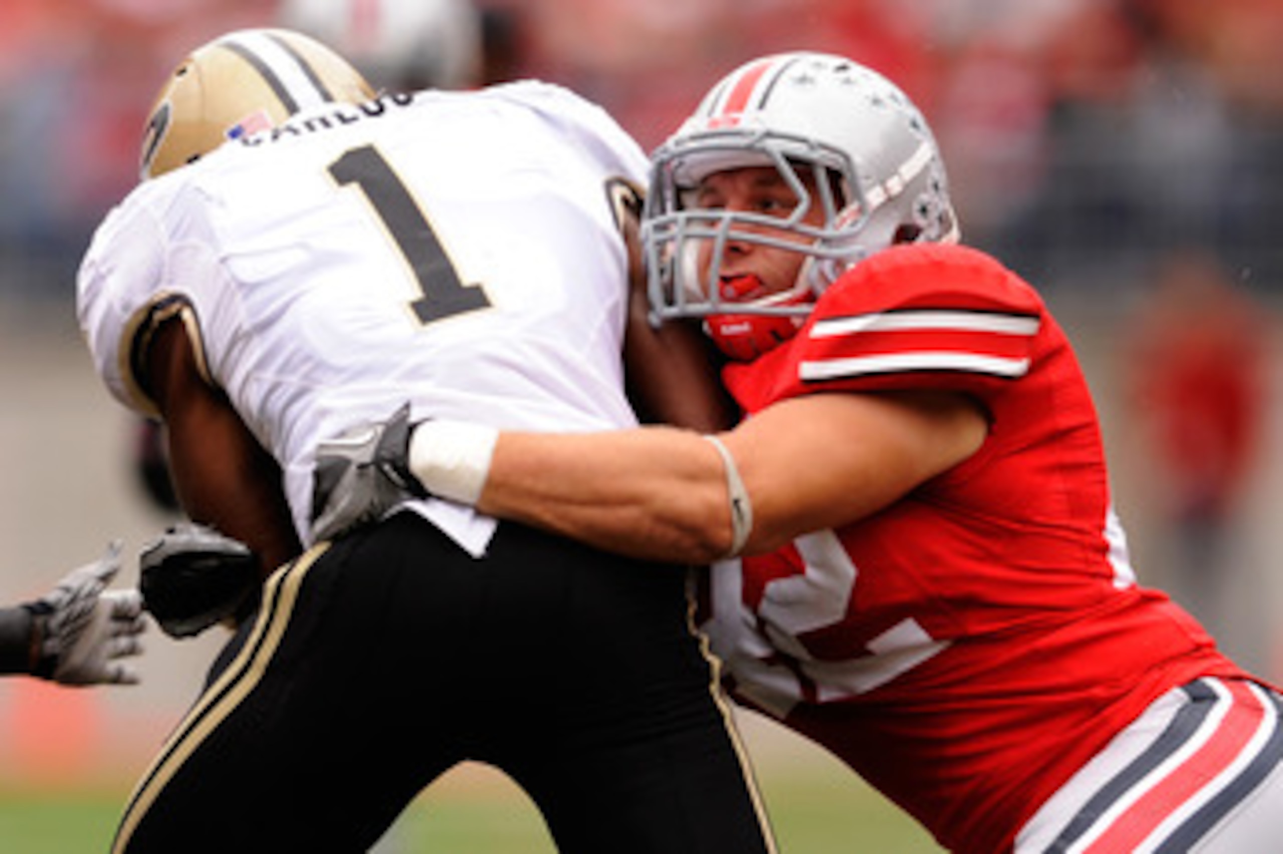 COLUMBUS, OH - OCTOBER 23:  Running back Keith Carlos #1 of the Purdue Boilermakers is tackled by Andrew Sweat #42 of the Ohio State Buckeyes at Ohio Stadium on October 23, 2010 in Columbus, Ohio.  (Photo by Jamie Sabau/Getty Images)