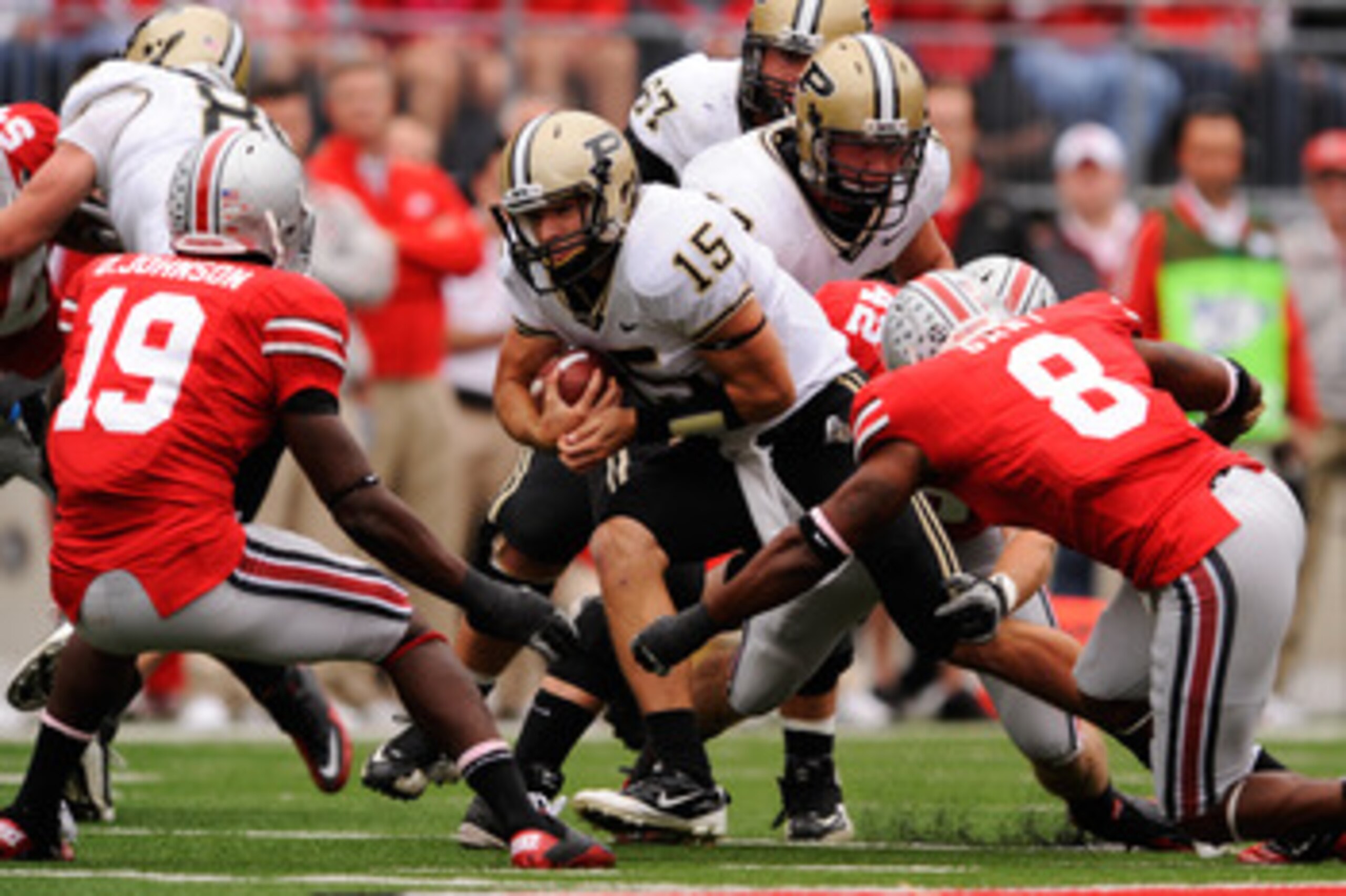 COLUMBUS, OH - OCTOBER 23:  Quarterback Rob Henry #15 of the Purdue Boilermakers looks for running room as Orhian Johnson #19 of the Ohio State Buckeyes and Aaron Gant #8 of the Ohio State Buckeyes close in for the tackle at Ohio Stadium on October 23, 20