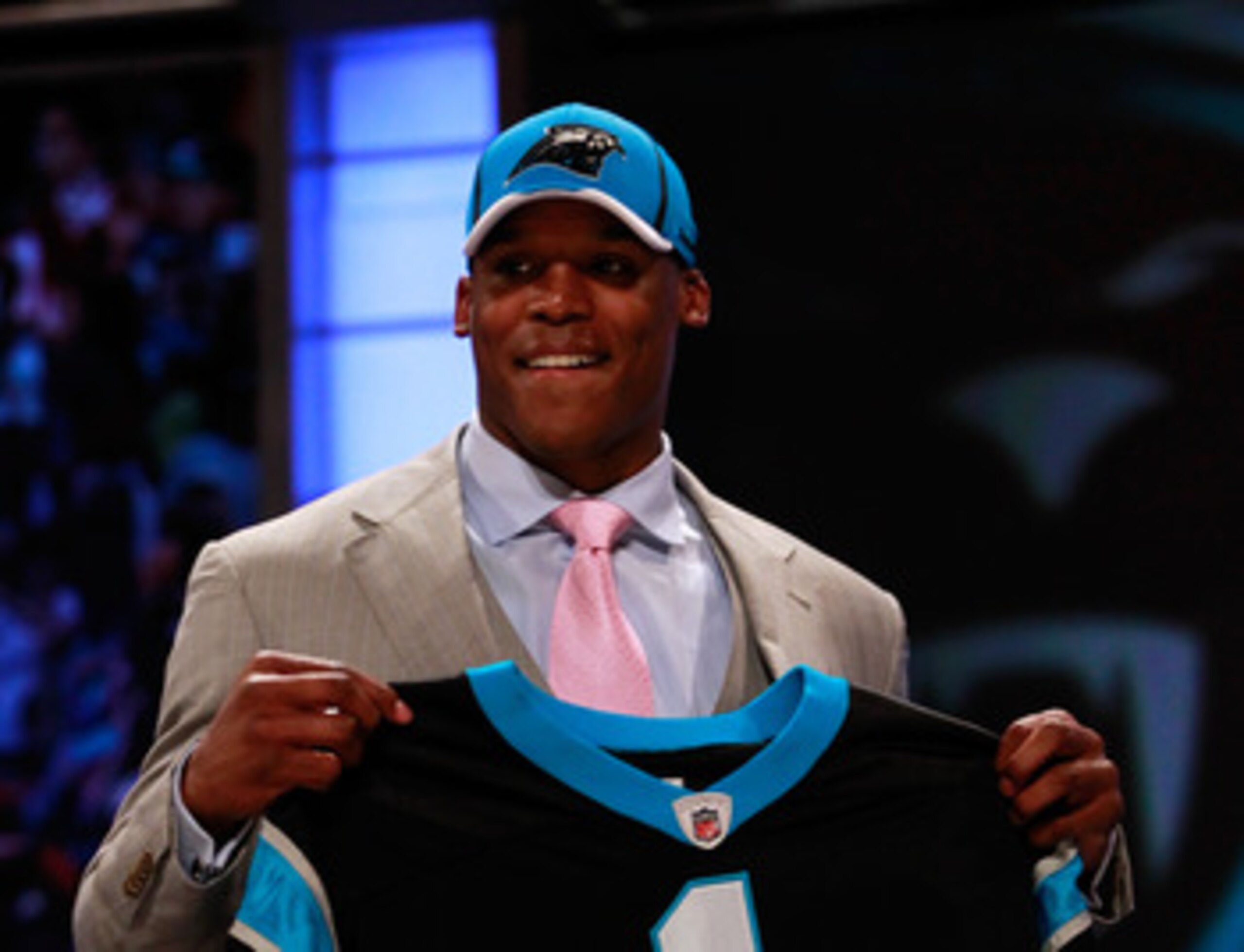 NEW YORK, NY - APRIL 28:  Cam Newton, #1 overall pick by the Carolina Panthers holds up a jersey on stage after he was picked during the 2011 NFL Draft at Radio City Music Hall on April 28, 2011 in New York City.  (Photo by Chris Trotman/Getty Images)