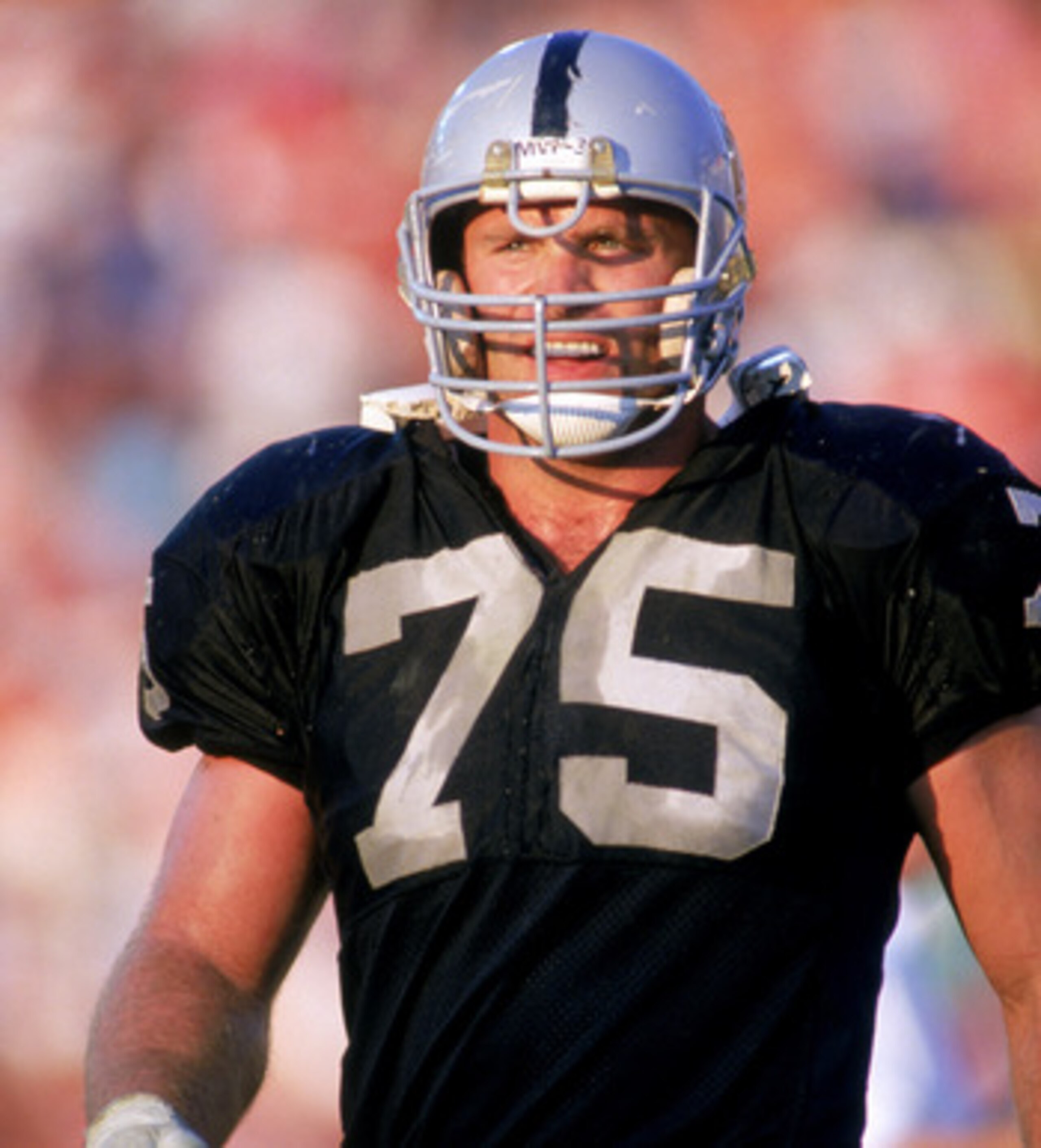 1987:  Defensive lineman Howie Long #75 of the Los Angeles Raiders walks on the field during a 1987 NFL season game.  (Photo by Mike Powell/Getty Images)