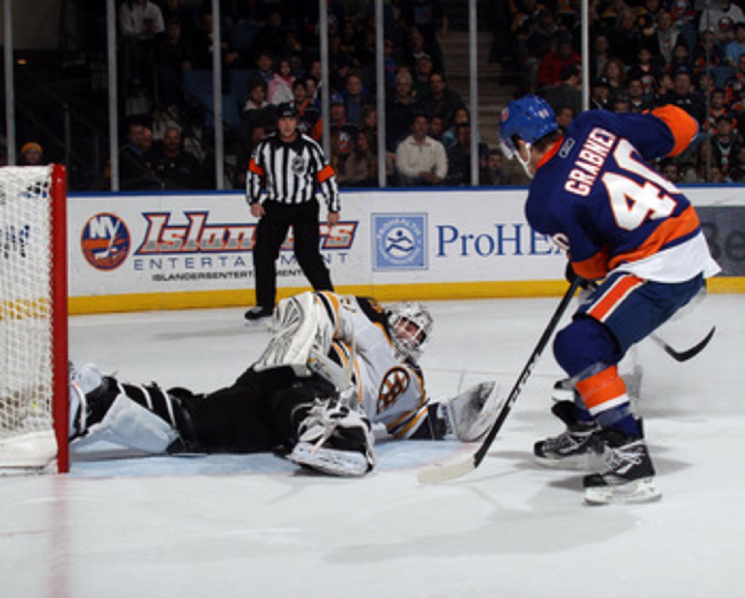 UNIONDALE, NY - MARCH 11: Tim Thomas #30 of the Boston Bruins stops Michael Grabner #40 of the New York Islanders during the second period at the Nassau Coliseum on March 11, 2011 in Uniondale, New York.  (Photo by Bruce Bennett/Getty Images)