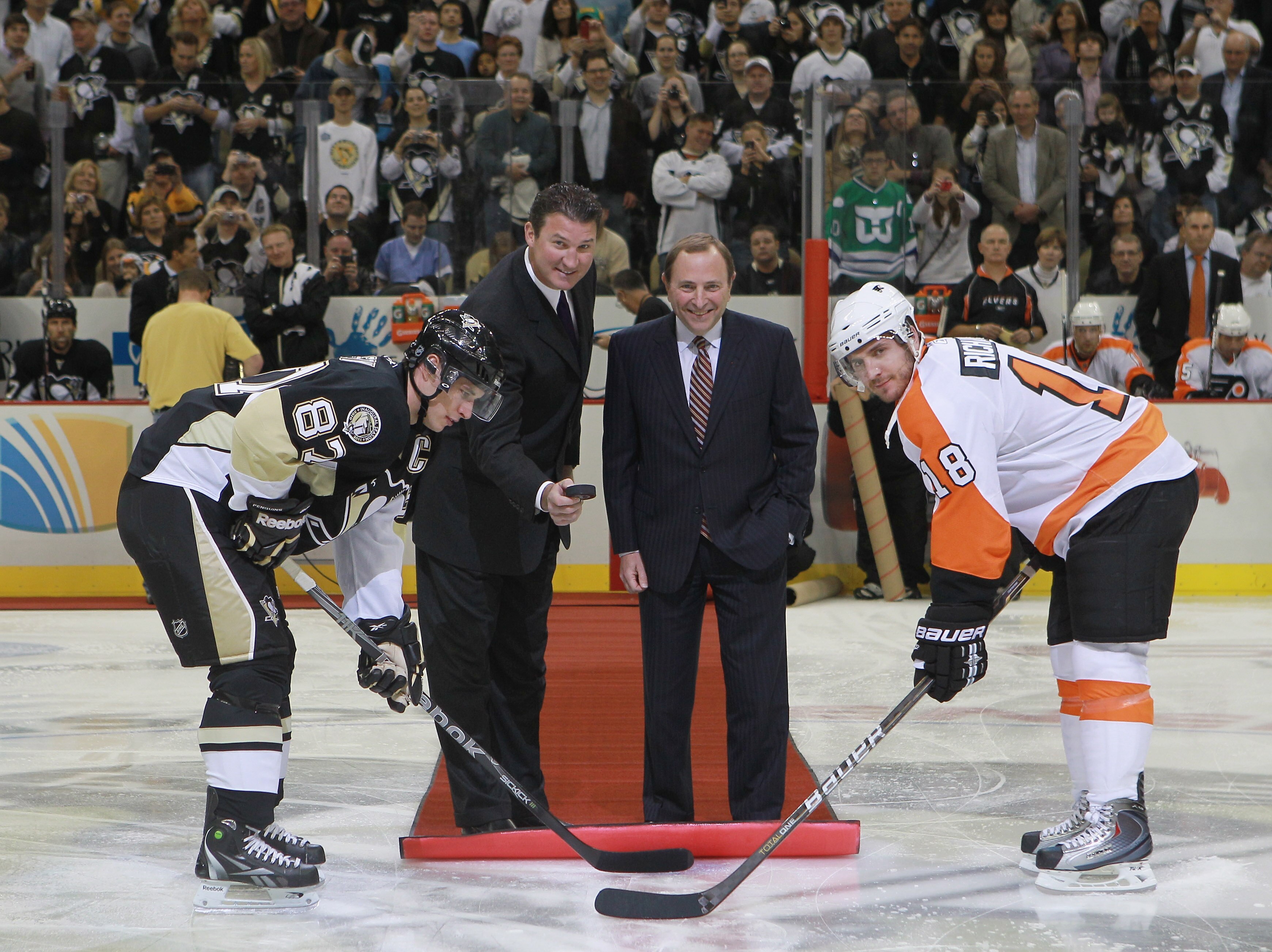 PITTSBURGH - OCTOBER 07:  Team owner Mario Lemieux of the Pittsburgh Penguins drops the puck between Sidney Crosby #87 of the Penguins and Mike Richards #18 of the Philadelphia Flyers as NHL commissioner Gary Bettman looks on prior to the arena opening ga