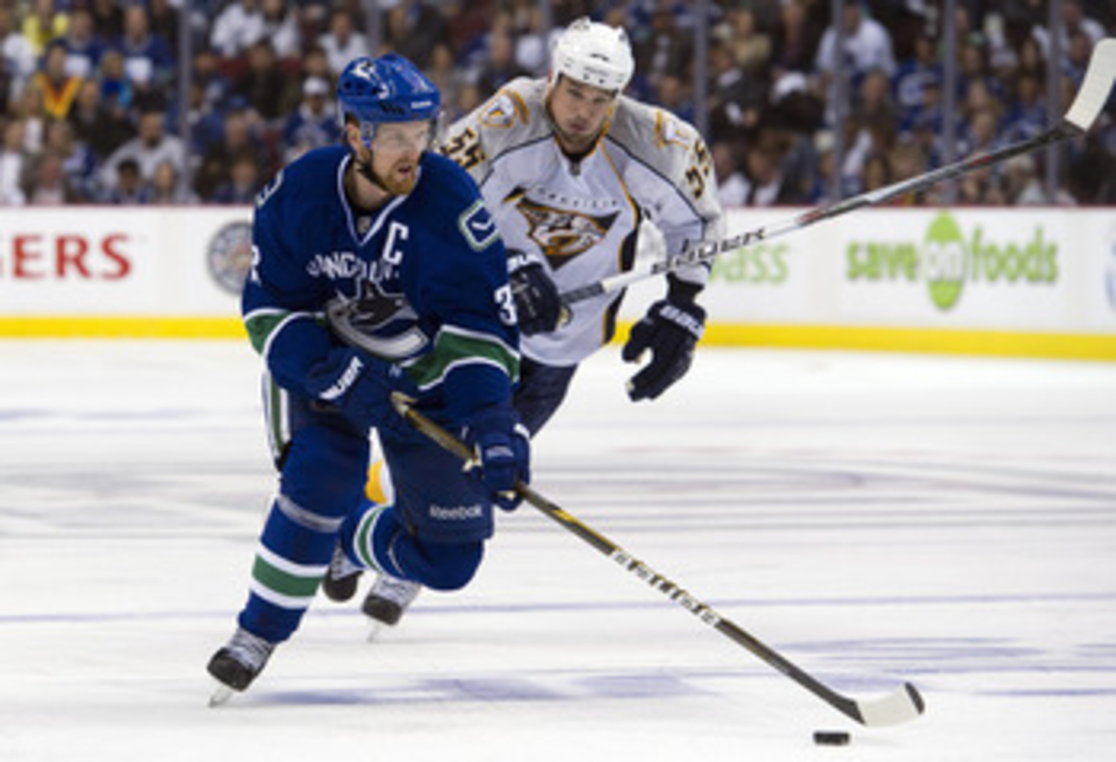 VANCOUVER, CANADA - APRIL 28: Henrik Sedin #33 of the Vancouver Canucks gains control of the puck after getting past Shane O'Brien #55 of the Nashville Predators during the second period in Game One of the Western Conference Semifinals during the 2011 NHL