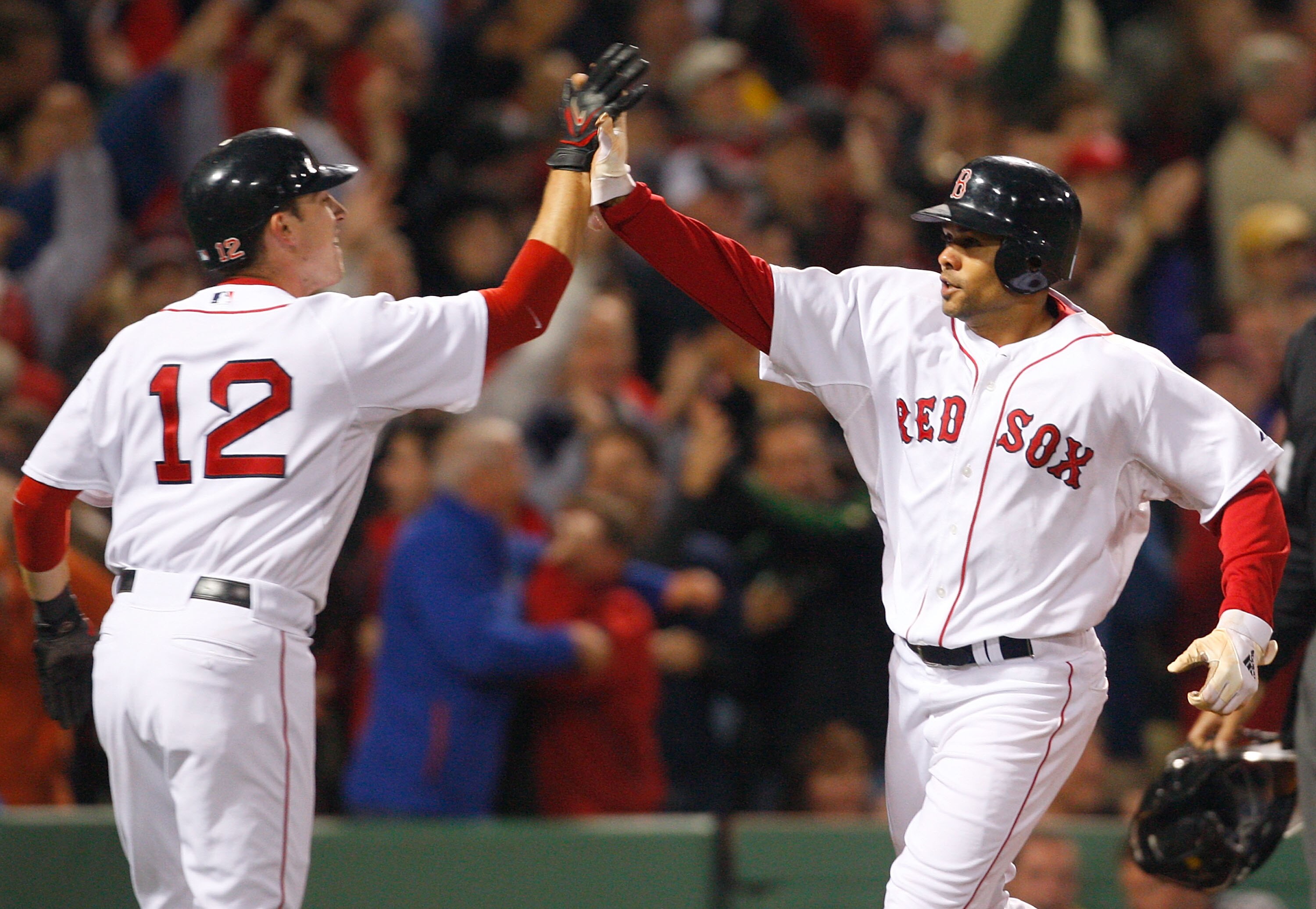 BOSTON - OCTOBER 5: Jed Lowrie #12 and Coco Crisp #10 score on a single hit by Jacoby Ellsbury #46 of the Boston Red Sox during game three of the American League Division Series against thLos Angeles Angels of Anaheim at Fenway Park on October 5, 2008 in