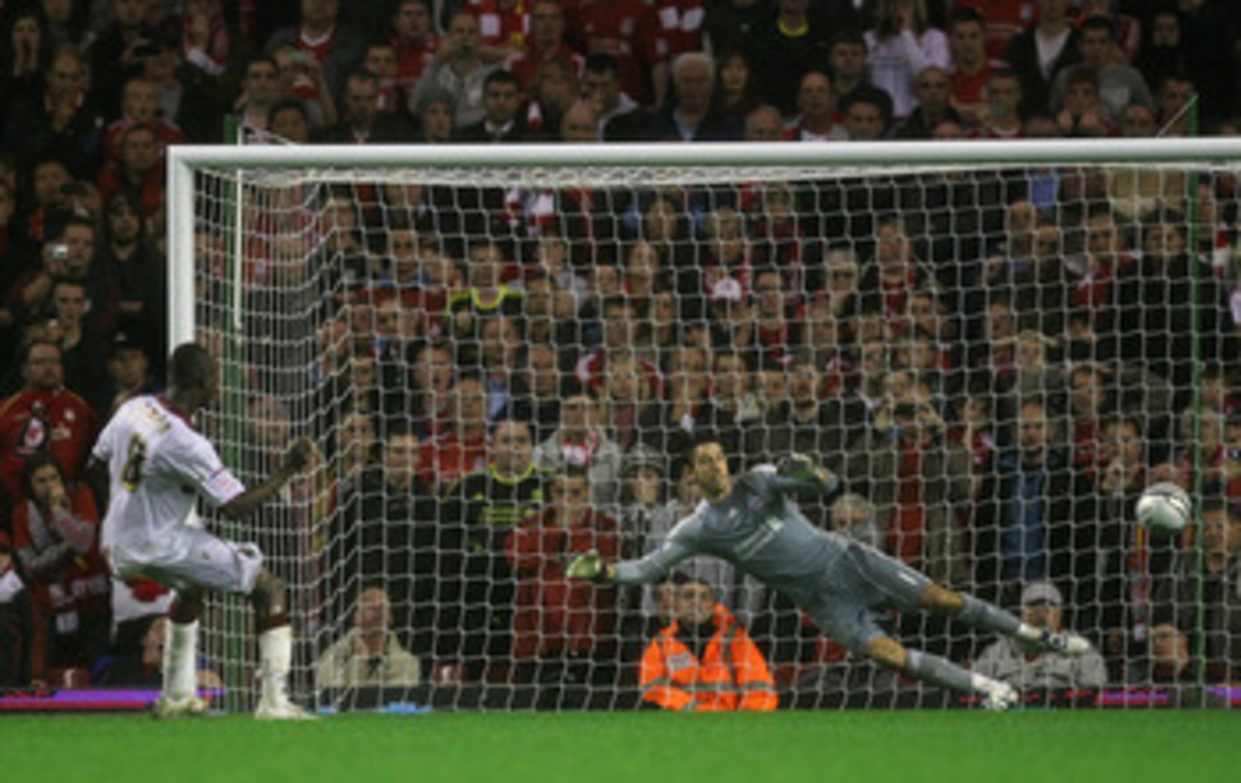 LIVERPOOL, ENGLAND - SEPTEMBER 22:  Abdul Osman of Northampton Town scores the winning penalty in a shootout past Brad Jones of Liverpool during the Carling Cup Third Round game between Liverpool and Northampton Town at Anfield on September 22, 2010 in Li