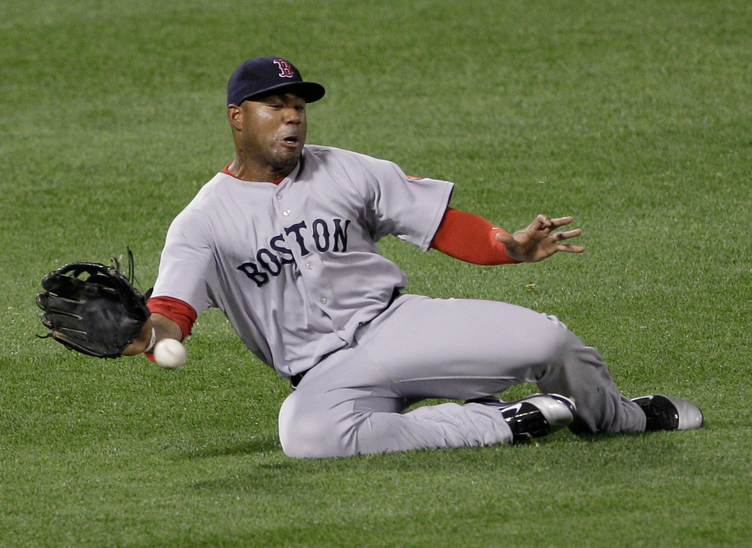 BALTIMORE, MD - APRIL 26:  Left fielder Carl Crawford #13 of the Boston Red Sox one hops a single by Vladimir Guerrero #27 of the Baltimore Orioles during the fifth inning at Oriole Park at Camden Yards on April 26, 2011 in Baltimore, Maryland.  (Photo by