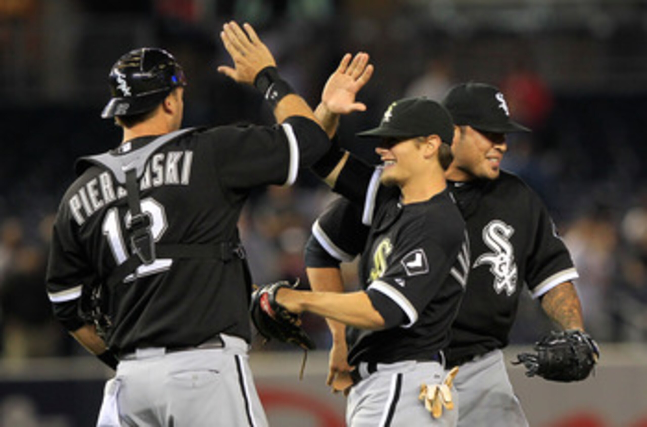 NEW YORK, NY - APRIL 26: (C) Brent Lillibridge #18 of the Chicago White Sox is congratulated by his teammates (L) A.J. Pierzynsk #12 and (R) Sergio Santos #46 for his catches in the ninth inning against the New York Yankees at Yankee Stadium on April 26,
