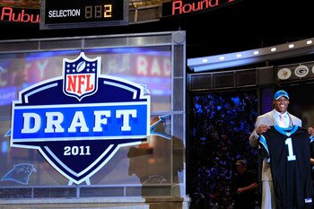 NEW YORK, NY - APRIL 28:  Cam Newton, #1 overall pick by the Carolina Panthers holds up a jersey on stage after he was picked during the 2011 NFL Draft at Radio City Music Hall on April 28, 2011 in New York City.  (Photo by Chris Trotman/Getty Images)