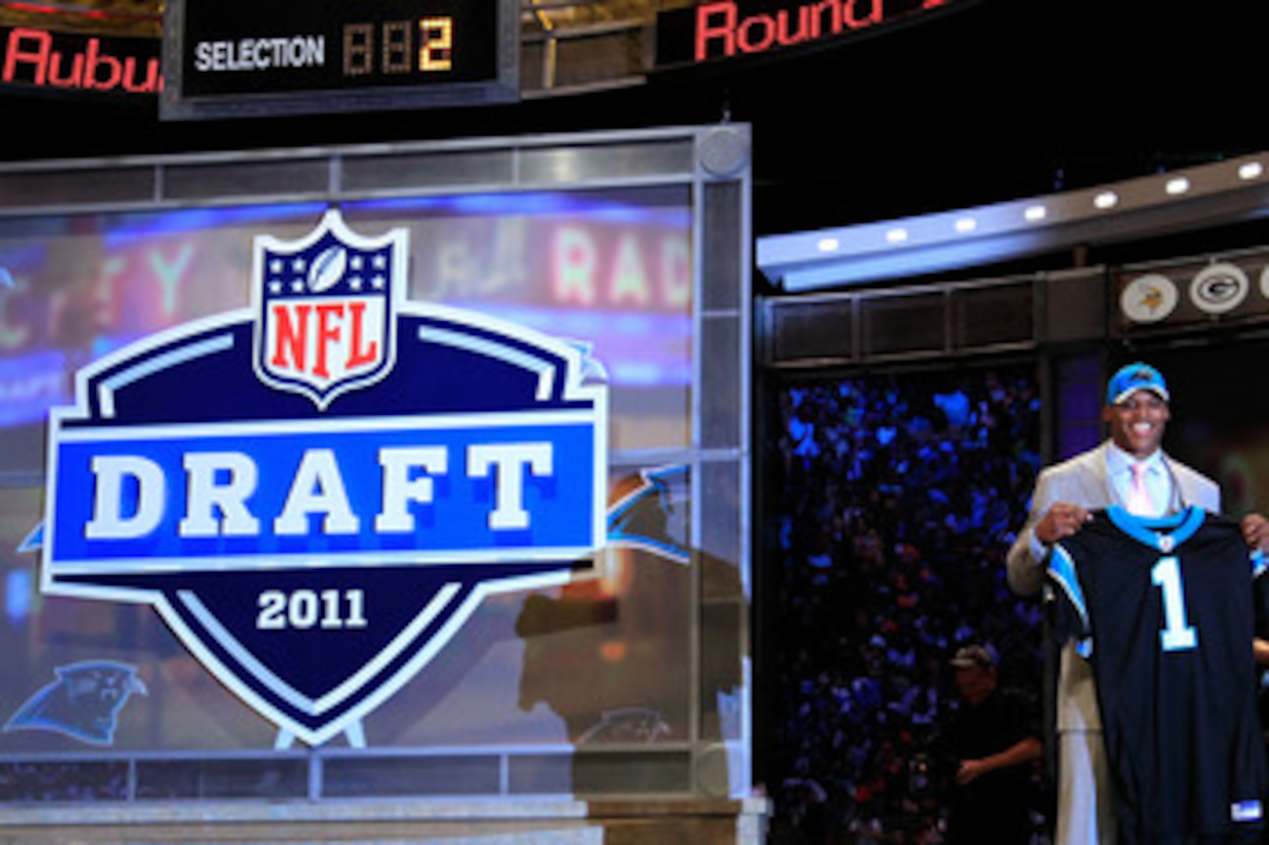 NEW YORK, NY - APRIL 28:  Cam Newton, #1 overall pick by the Carolina Panthers holds up a jersey on stage after he was picked during the 2011 NFL Draft at Radio City Music Hall on April 28, 2011 in New York City.  (Photo by Chris Trotman/Getty Images)