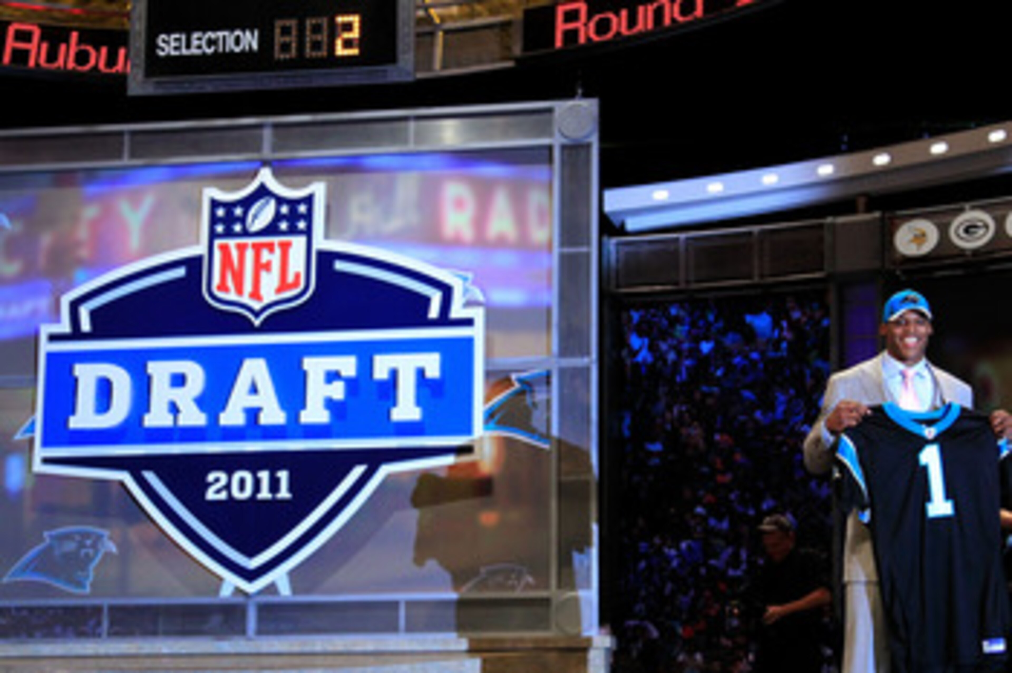 NEW YORK, NY - APRIL 28:  Cam Newton, #1 overall pick by the Carolina Panthers holds up a jersey on stage after he was picked during the 2011 NFL Draft at Radio City Music Hall on April 28, 2011 in New York City.  (Photo by Chris Trotman/Getty Images)
