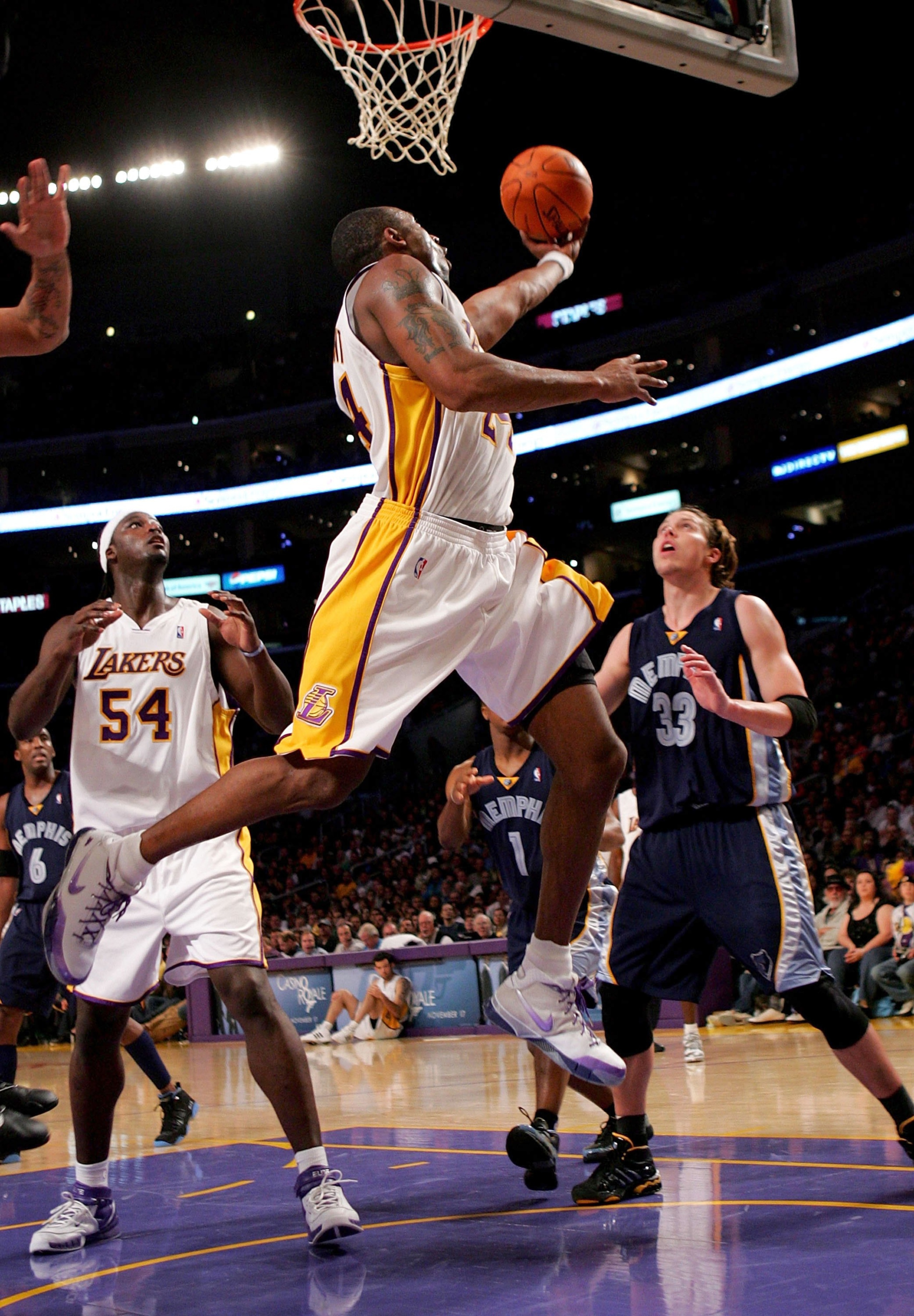 LOS ANGELES - NOVEMBER 12:  Kobe Bryant #24 of the Los Angeles Lakers puts up a reverse layup in front of teammate Kwame Brown #54 and Mike Miller #33 of the Memphis Grizzlies on November 12, 2006 at Staples Center in Los Angeles, California. The Lakers d