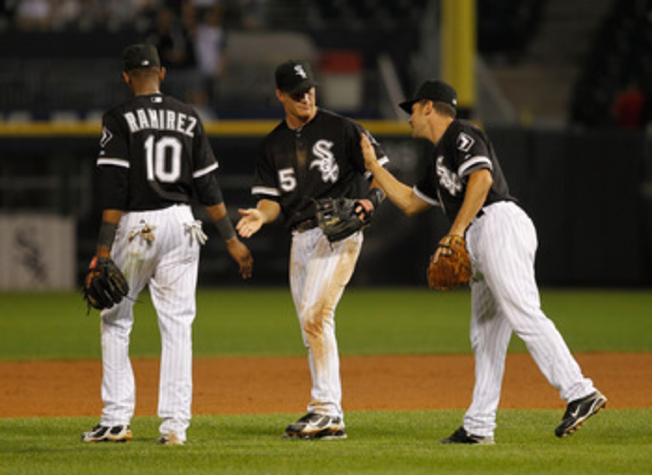 CHICAGO - JULY 07: (L-R) Alexei Ramirez #10, Gordan Beckham #15 and Omar Vizquel #11 of the Chicago White Sox celebrate a win over the Los Angeles Angels of Anaheim at U.S. Cellular Field on July 7, 2010 in Chicago, Illinois. The White Sox defeated the An