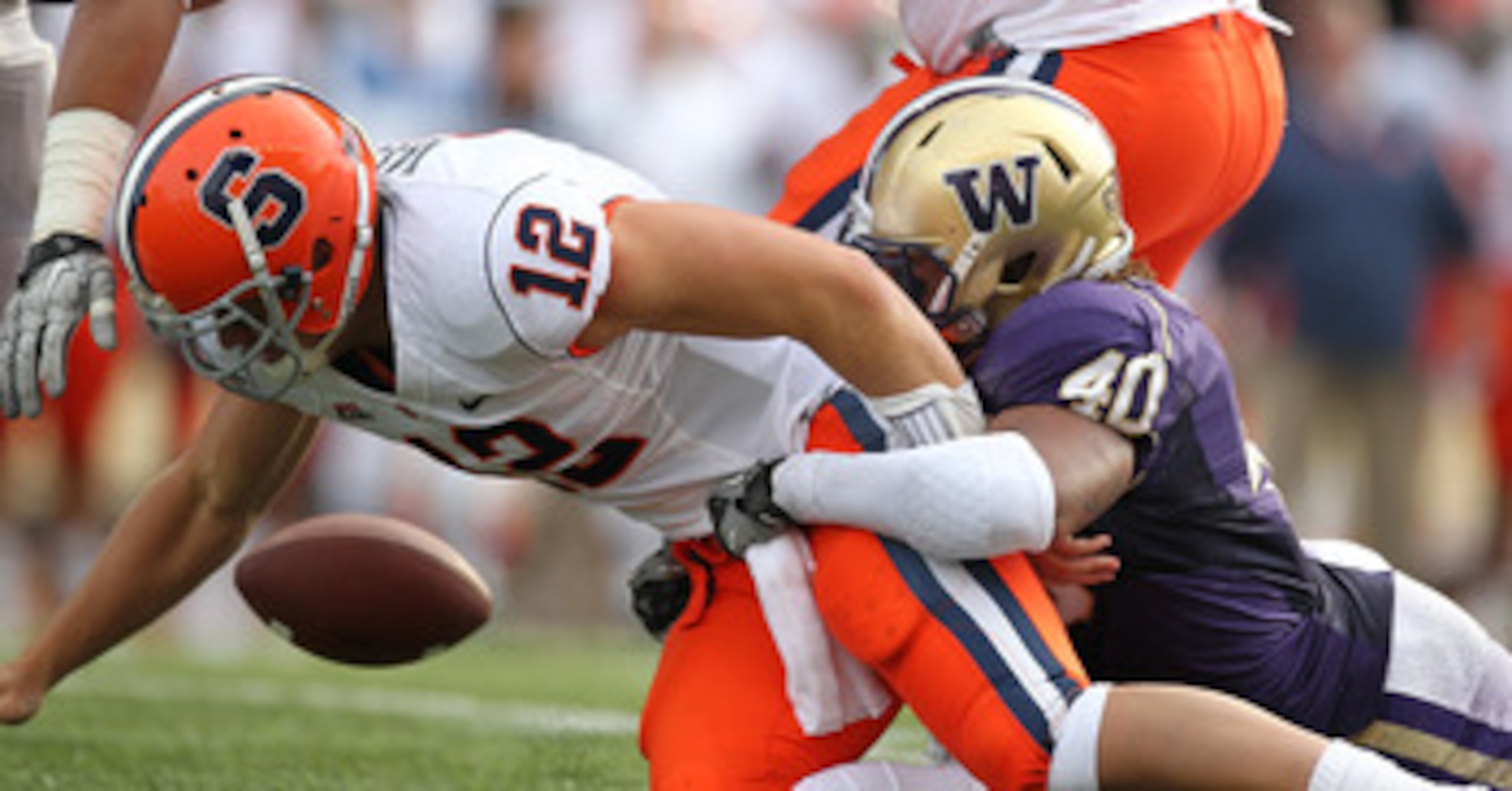 SEATTLE - SEPTEMBER 11:  Quarterback Ryan Nassib #12 of the Syracuse Orange fumbles the ball against Mason Foster #40 of the Washington Huskies on September 11, 2010 at Husky Stadium in Seattle, Washington. The Huskies defeated the Orange 41-20. (Photo by