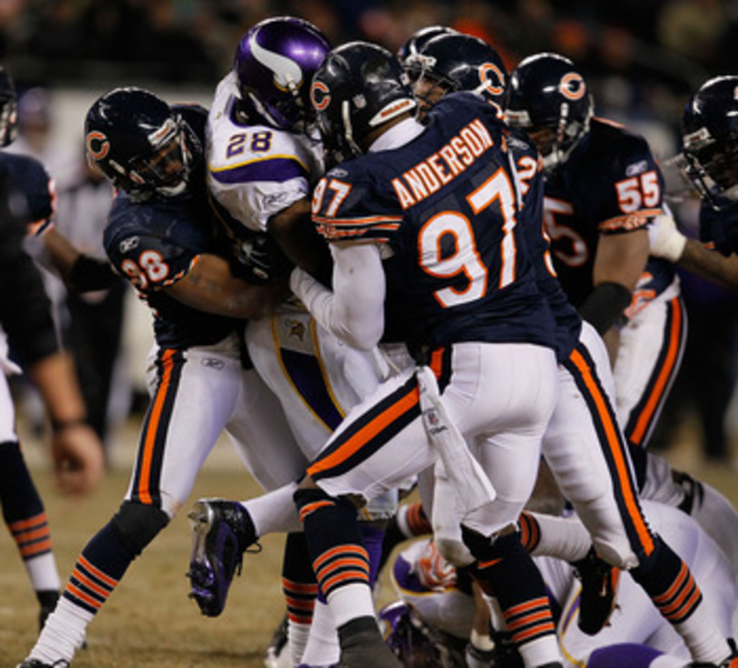 CHICAGO - DECEMBER 28: Adrian Peterson #28 of the Minnesota Vikings is gang-tackled by members of the Chicago Bears including Danieal Manning #38 and Mark Anderson #97 at Soldier Field on December 28, 2009 in Chicago, Illinois. The Bears defeated the Viki