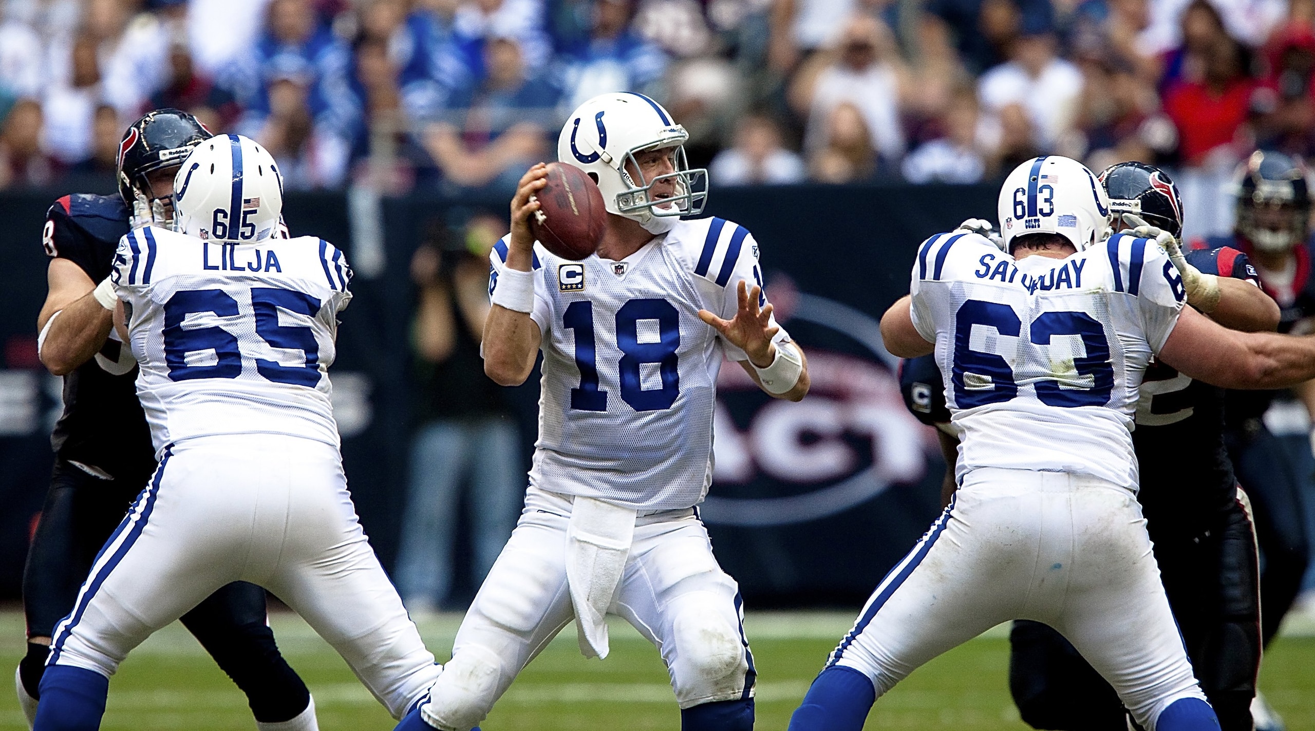 HOUSTON - NOVEMBER 29:  Quarterback Peyton Manning #18 of the Indianapolis Colts looks for an open receiver as he receives protection from offensive guard Ryan Lilja #65 and center Jeff Saturday #63 against the Houston Texans at Reliant Stadium on Novembe
