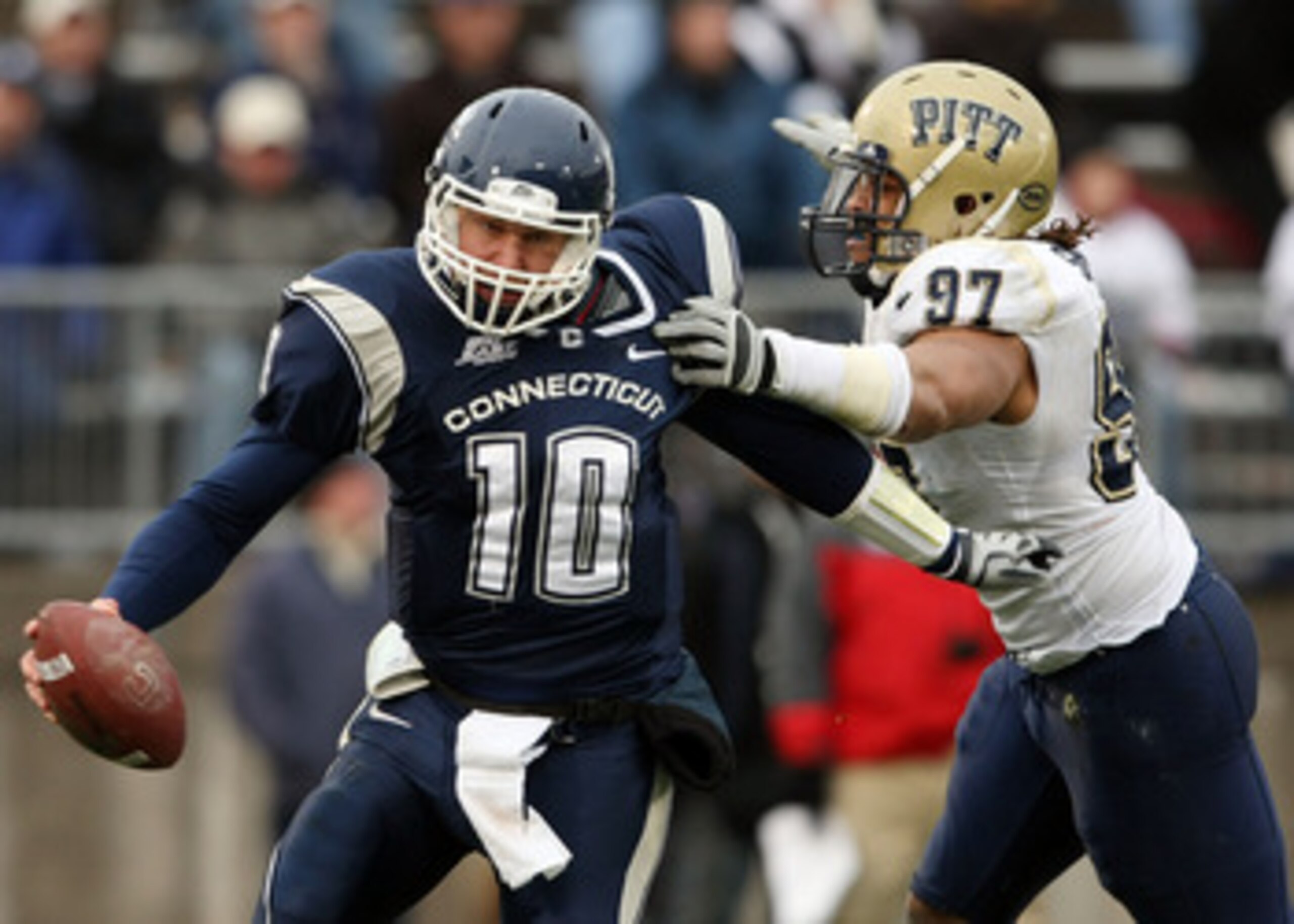 EAST HARTFORD, CT - DECEMBER 06:  Zach Frazer #10 of the Connecticut Huskies narrowly escapes Jabaal Sheard #97 of the Pittsburgh Panthers on December 6, 2008 at Rentschler Field in East Hartford, Connecticut. The Panthers defeated the Huskies 34-10.  (Ph