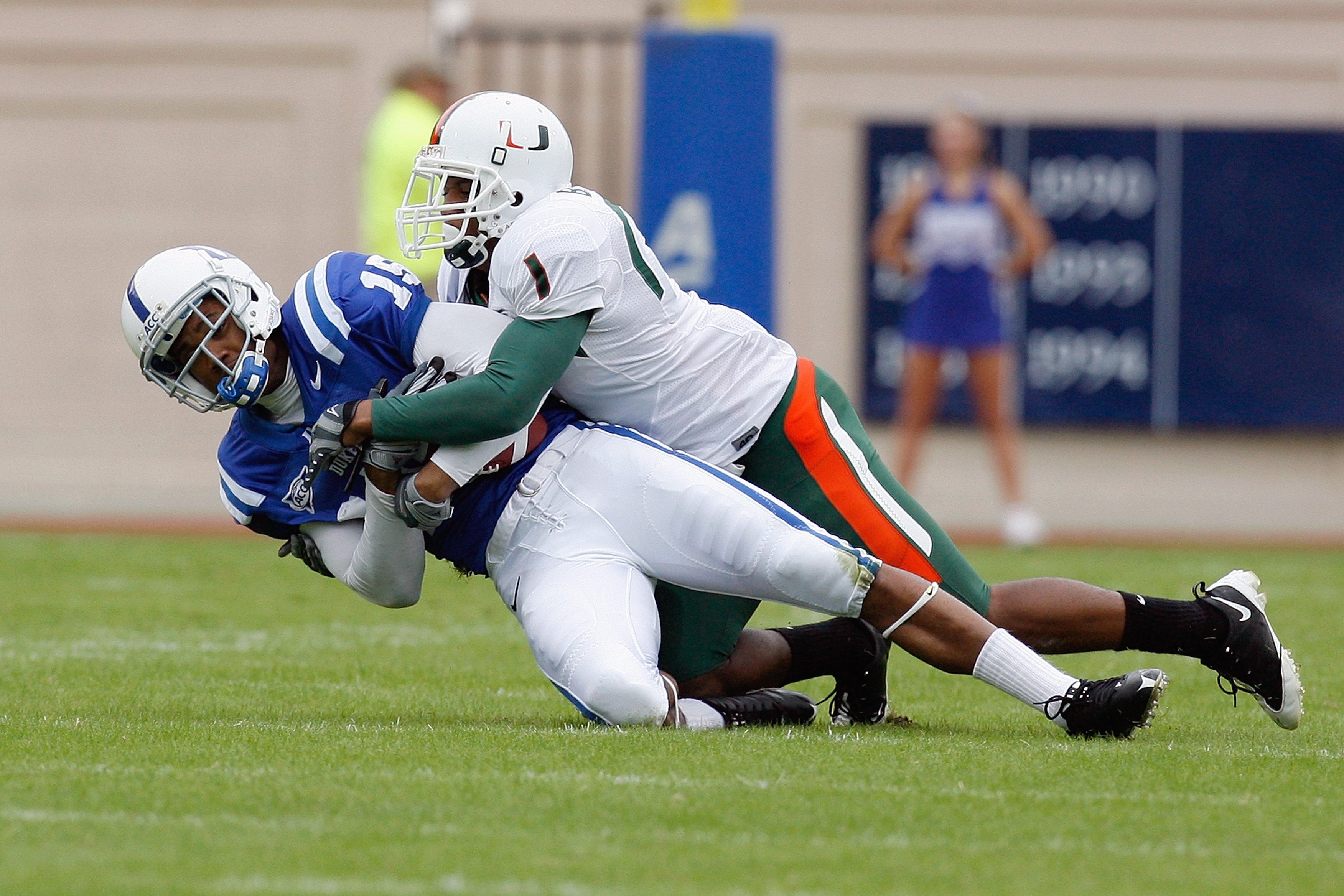 DURHAM, NC - OCTOBER 18:  Eron Riley #15 of the Duke Blue Devils grips the ball as he is tackled by Brandon Harris #1 of the Miami Hurricanes at Wallace Wade Stadium on October 18, 2008 in Durham, North Carolina.  (Photo by Kevin C. Cox/Getty Images)