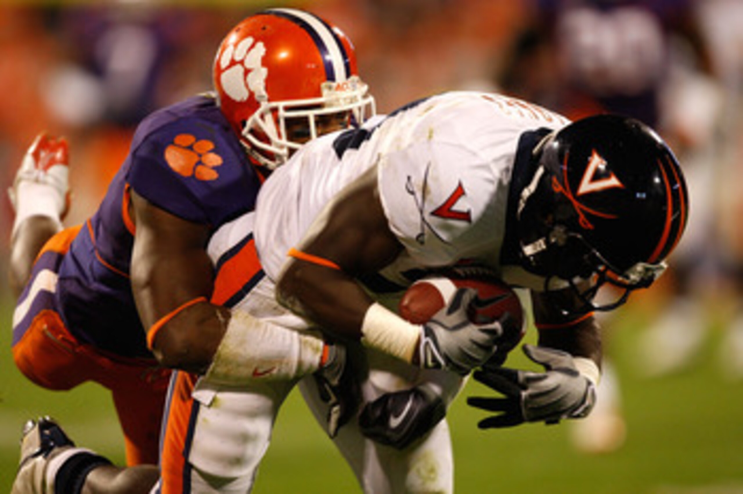 CLEMSON, SC - NOVEMBER 21:  Perry Jones #33 of the Virginia Cavaliers catches a ball as Marcus Gilchrist #12 of the Clemson Tigers tackles him during their game at Memorial Stadium on November 21, 2009 in Clemson, South Carolina.  (Photo by Streeter Lecka