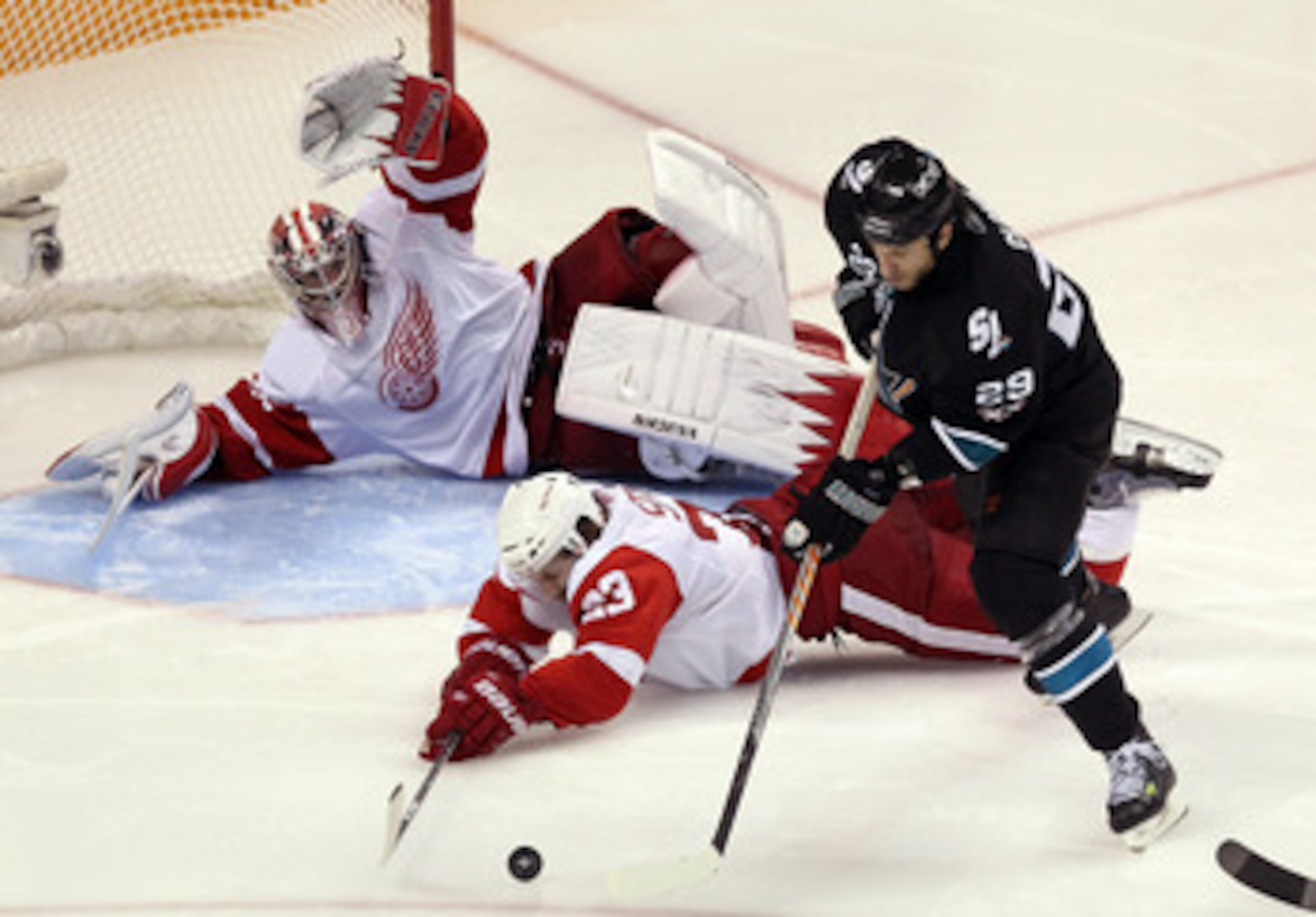 SAN JOSE, CA - APRIL 29:  Brad Stuart #23 and Jimmy Howard #35 of the Detroit Red Wings dive to stop a shot by Ryane Clowe #29 of the San Jose Sharks in Game One of the Western Conference Semifinals during the 2011 NHL Stanley Cup Playoffs at HP Pavilion