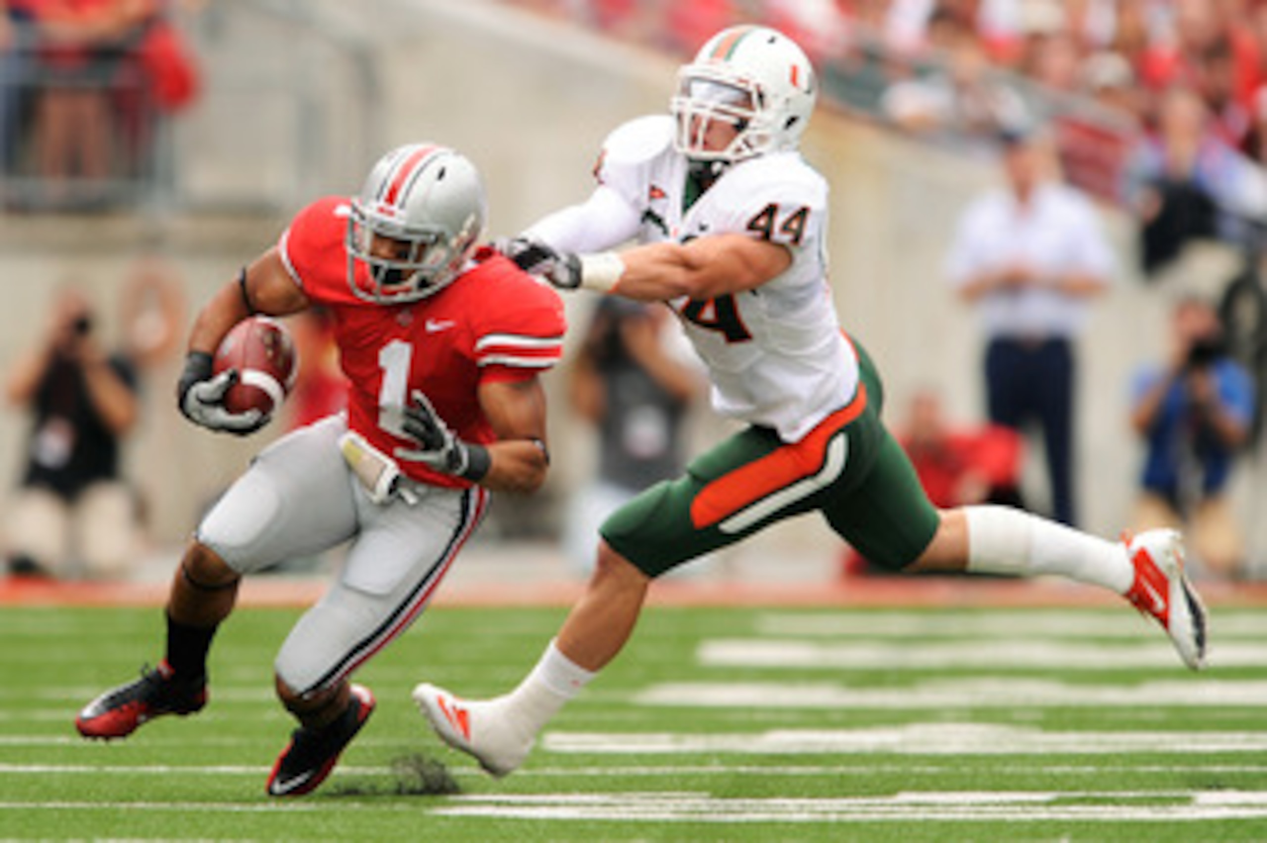 COLUMBUS, OH - SEPTEMBER 11:  Colin McCarthy #44 of the Miami Hurricanes attempts to tackle Dan Herron #1 of the Ohio State Buckeyes at Ohio Stadium on September 11, 2010 in Columbus, Ohio.  (Photo by Jamie Sabau/Getty Images)