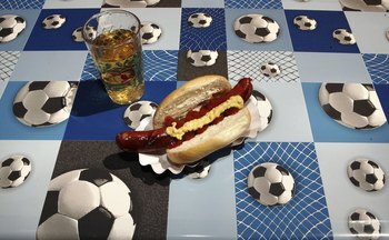 FRANKFURT, GERMANY - JUNE 11:  A hot dog and apple juice drink sit on a football patterned table cloth on June 11, 2006 in Frankfurt, Germany. On the third day of the FIFA World Cup three matches will take place in Leipzig, Nuremberg and Cologne.  (Photo