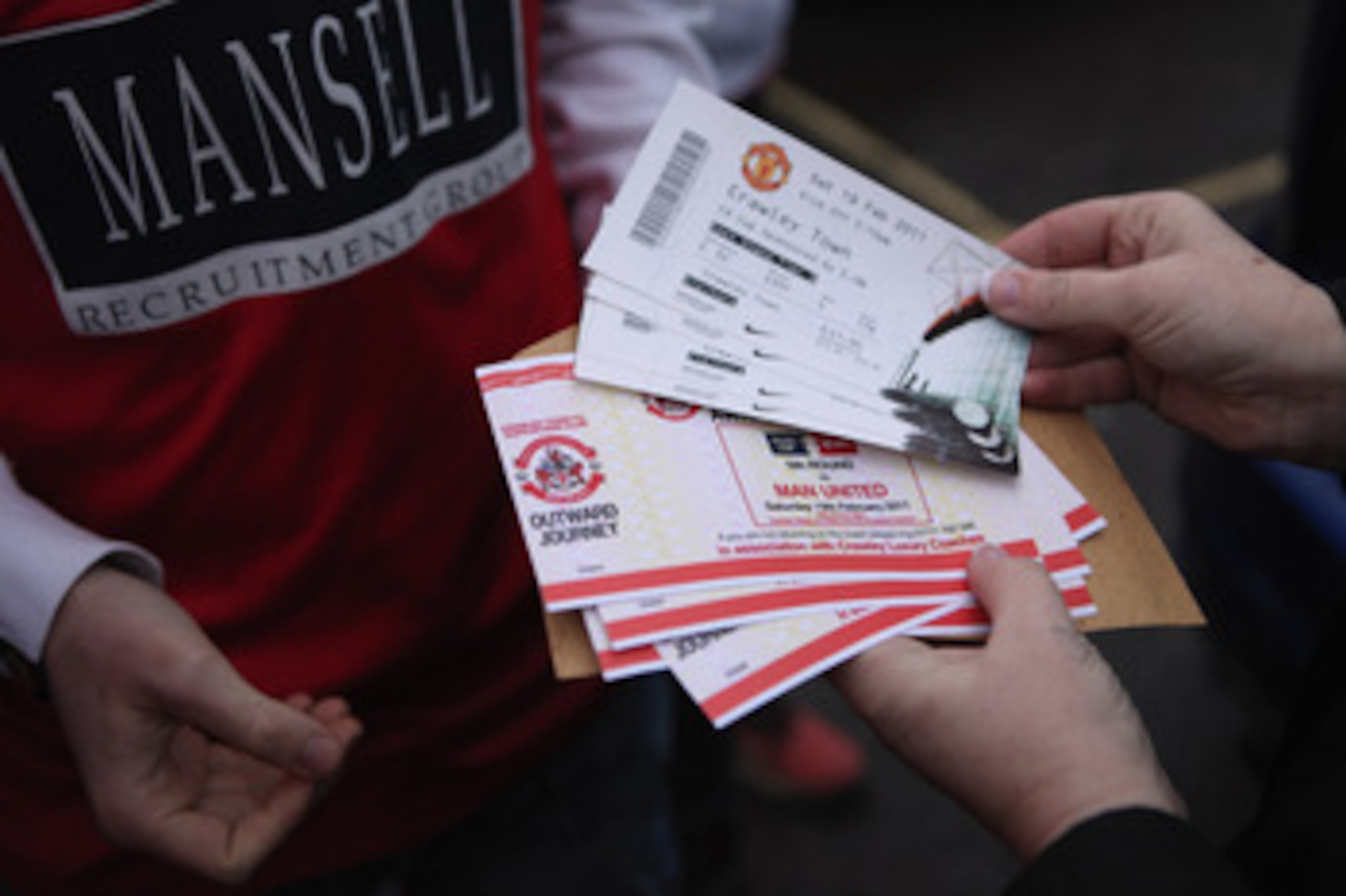 CRAWLEY, WEST SUSSEX - FEBRUARY 19: Fans of the non-league football club Crawley Town hand out tickets before boarding coaches to Manchester to watch their team take on Manchester United in the FA Cup fifth round on February 19, 2011 in Crawley, England CRAWLEY, WEST SUSSEX - FEBRUARY 19: Fans of the non-league football club Crawley Town hand out tickets before boarding coaches to Manchester to watch their team take on Manchester United in the FA Cup fifth round on February 19, 2011 in Crawley, England