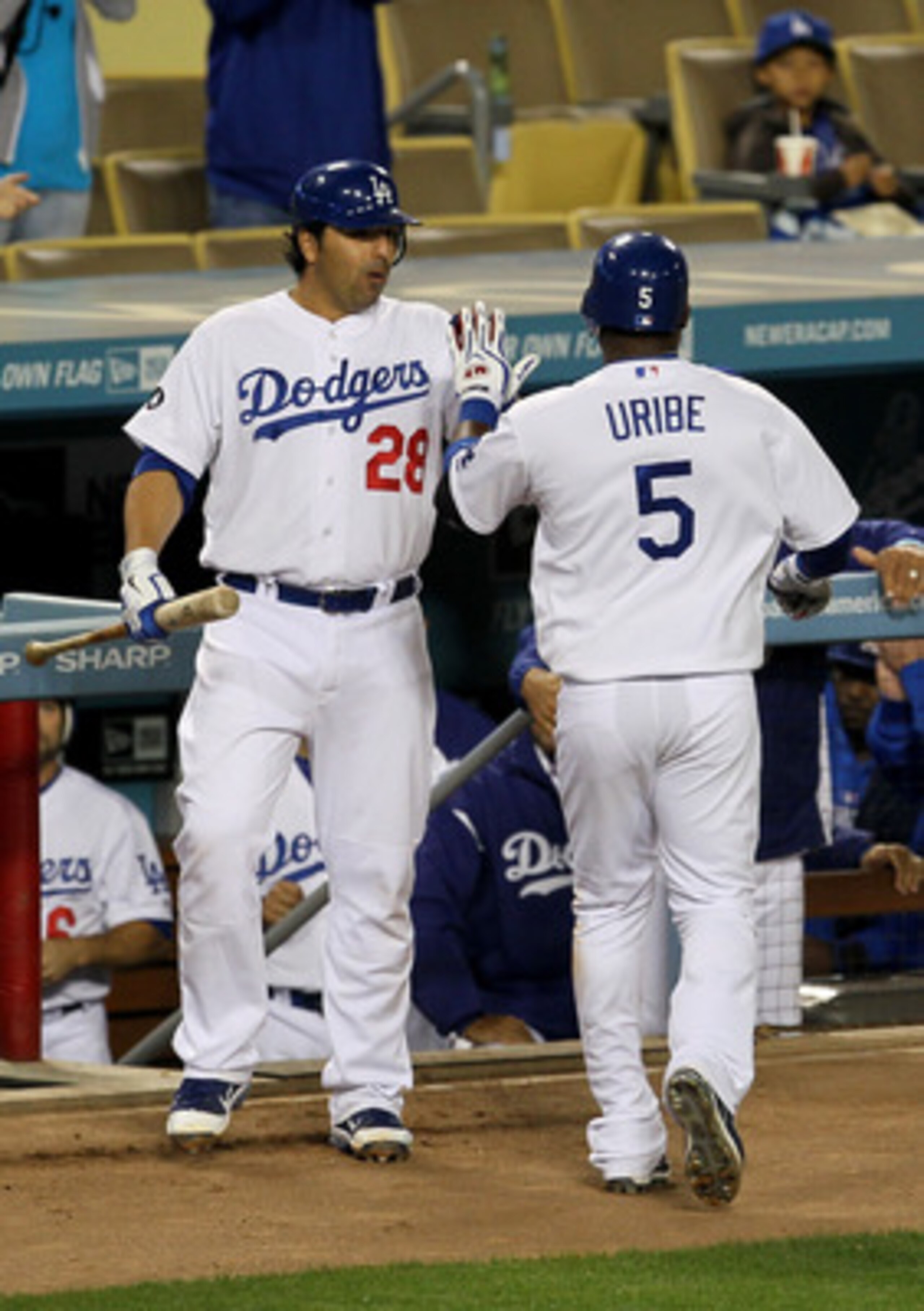 LOS ANGELES - APRIL 29:   Juan Uribe #5 of the Los Angeles Dodgers is greeted by Rod Barajas #28 as he returns to the dugout after hitting a solo home run in the fourth inning against the San Diego Padres on April 29, 2011 at Dodger Stadium in Los Angeles