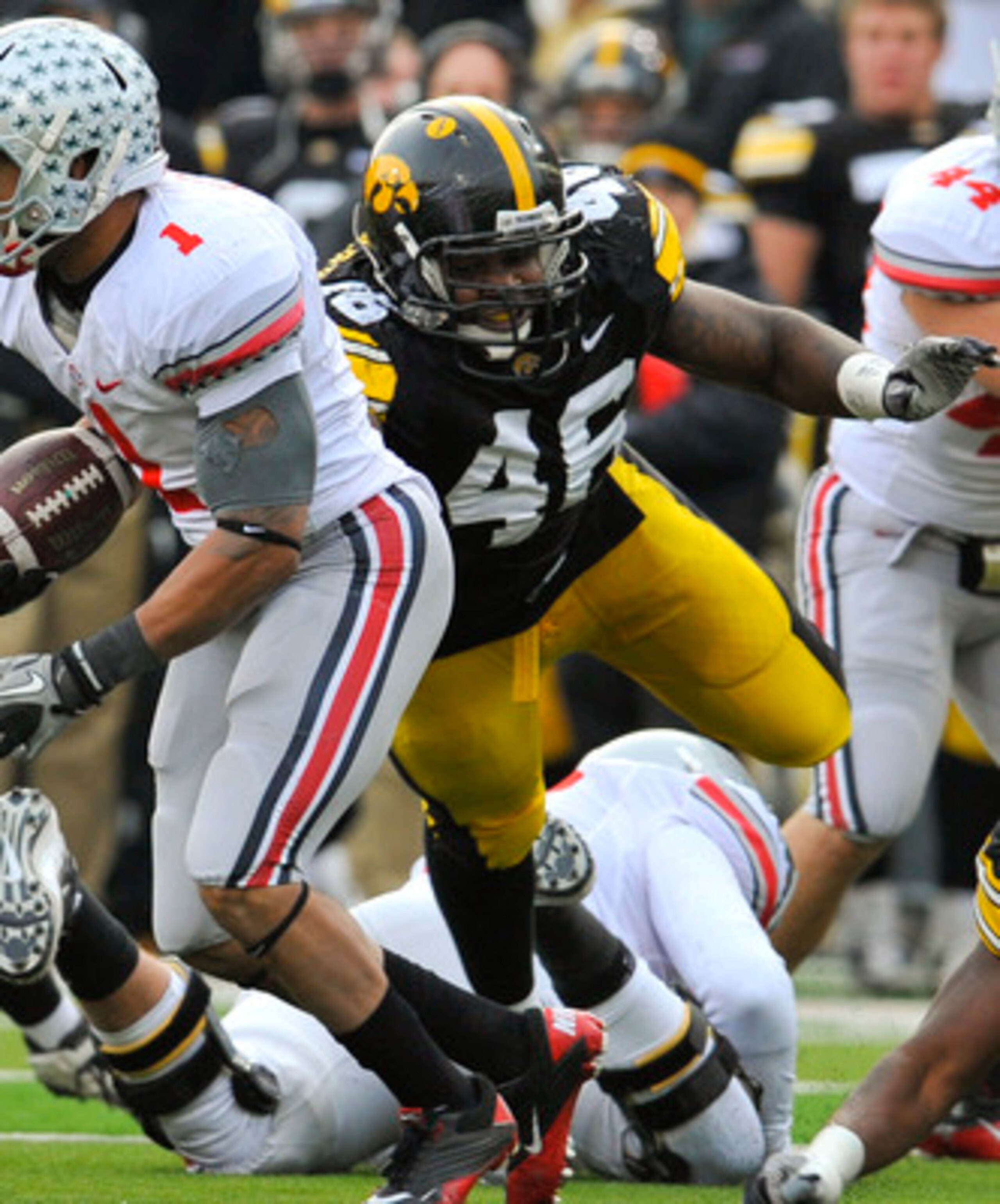 IOWA CITY, IA - NOVEMBER 20:  Tailback Dan Herron #1 of the Ohio State Buckeyes scrambles for yards past defensive end Christian Ballard $46 of the University of Iowa Hawkeyes during the second half of play at Kinnick Stadium on November 20, 2010 in Iowa
