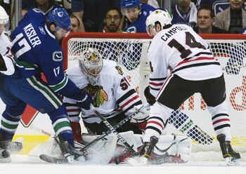 VANCOUVER, CANADA - APRIL 26: Ryan Kesler #17 of the Vancouver Canucks tips the puck towards goalie Corey Crawford #50 of the Chicago Blackhawks while being watched by Chris Campoli #14 of the Chicago Blackhawks during the first period in Game Seven of th