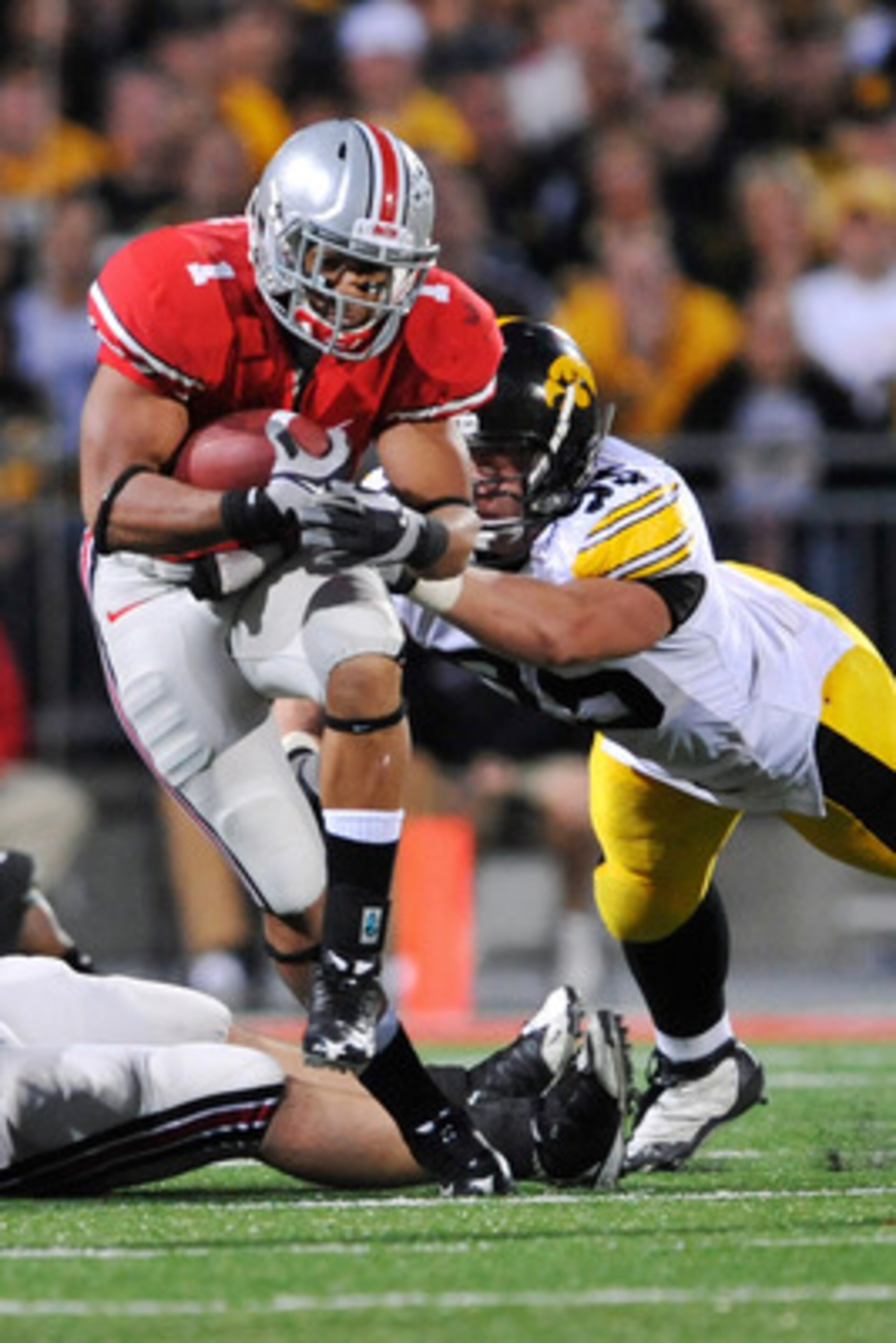 COLUMBUS, OH - NOVEMBER 14:  Running back Dan Herron #1 of the Ohio State Buckeyes tries to elude the grasp of Karl Klug #95 of the Iowa Hawkeyes at Ohio Stadium on November 14, 2009 in Columbus, Ohio.  (Photo by Jamie Sabau/Getty Images)