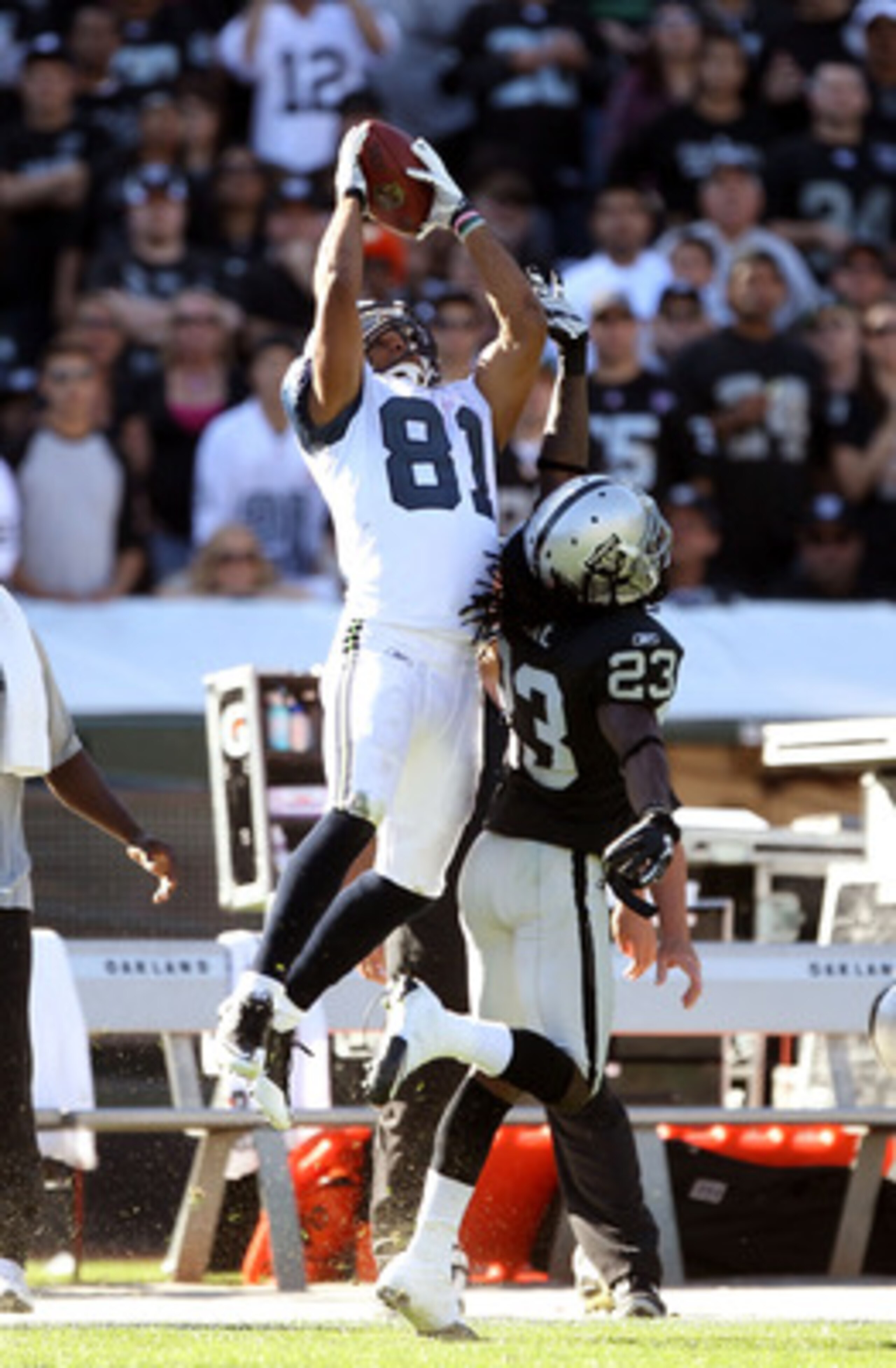 OAKLAND, CA - OCTOBER 31:  Golden Tate #81 of the Seattle Seahawks makes a leaping catch over Jeremy Ware #23 of the Oakland Raiders at Oakland-Alameda County Coliseum on October 31, 2010 in Oakland, California.  (Photo by Ezra Shaw/Getty Images)
