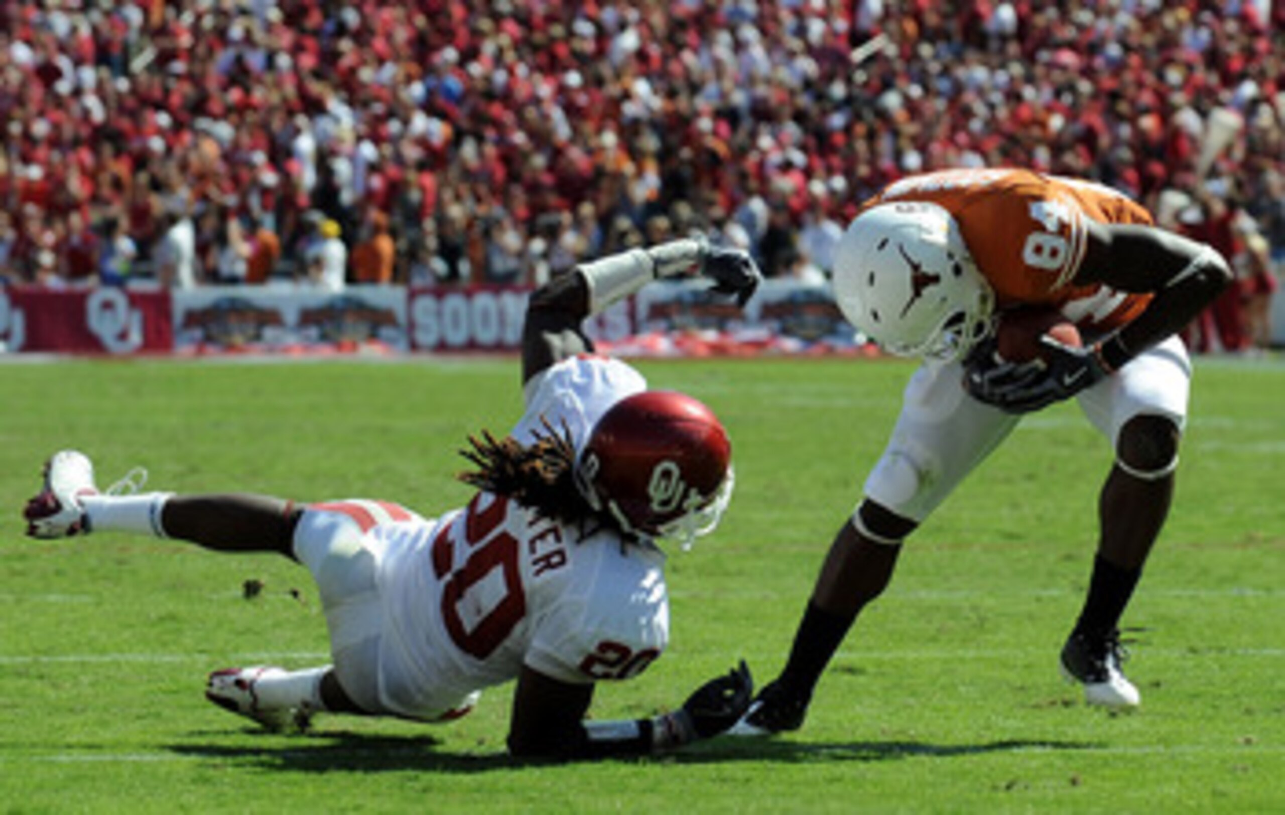 DALLAS - OCTOBER 17:  Wide receiver Marquise Goodwin #84 of the Texas Longhorns runs for a touchdown against Quinton Carter #20 of the Oklahoma Sooners at Cotton Bowl on October 17, 2009 in Dallas, Texas.  (Photo by Ronald Martinez/Getty Images)
