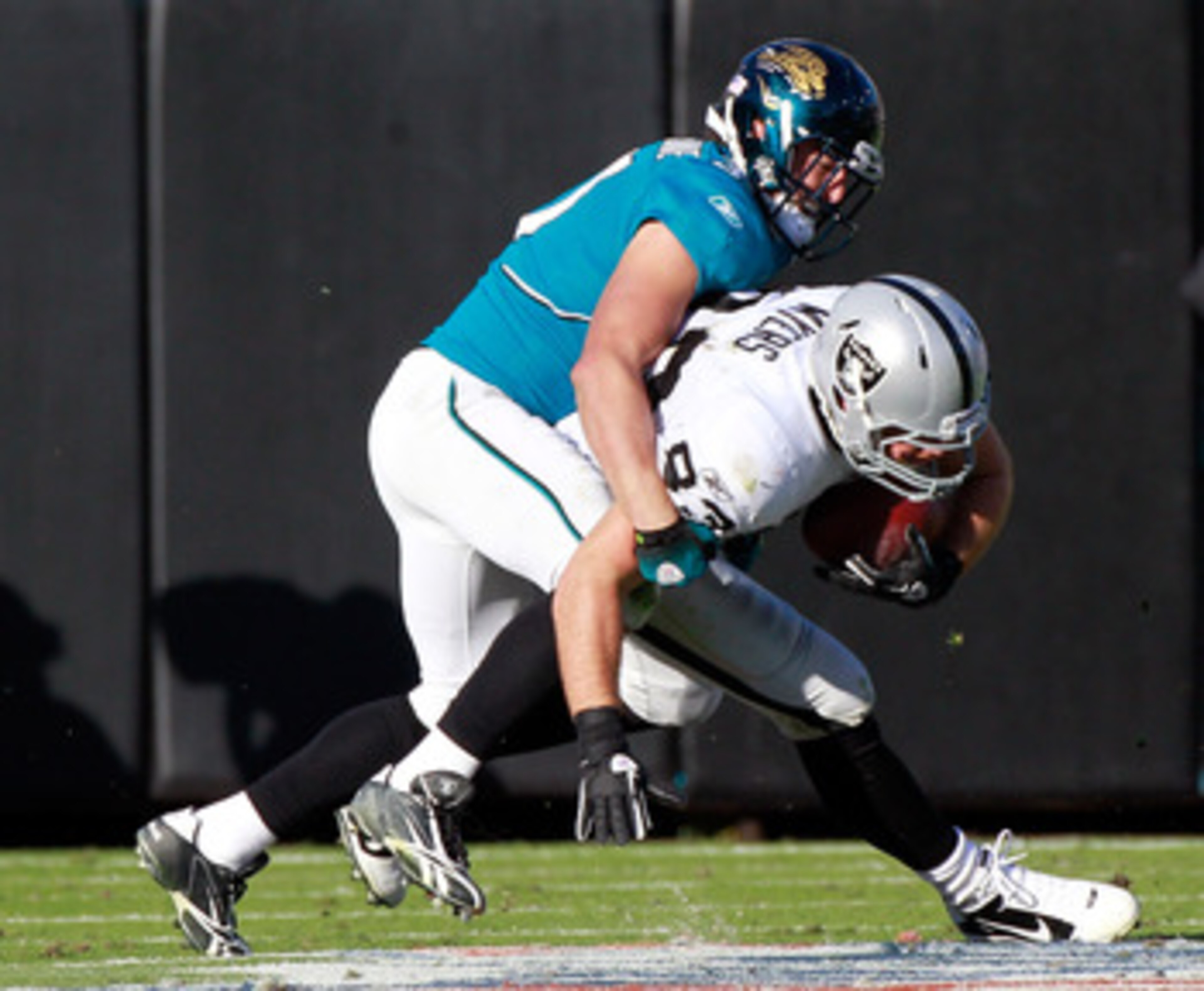 JACKSONVILLE, FL - DECEMBER 12:  Sean Considine #37 of the Jacksonville Jaguars tackles Brandon Myers #83 of the Oakland Raiders during the game at EverBank Field on December 12, 2010 in Jacksonville, Florida.  (Photo by Sam Greenwood/Getty Images)