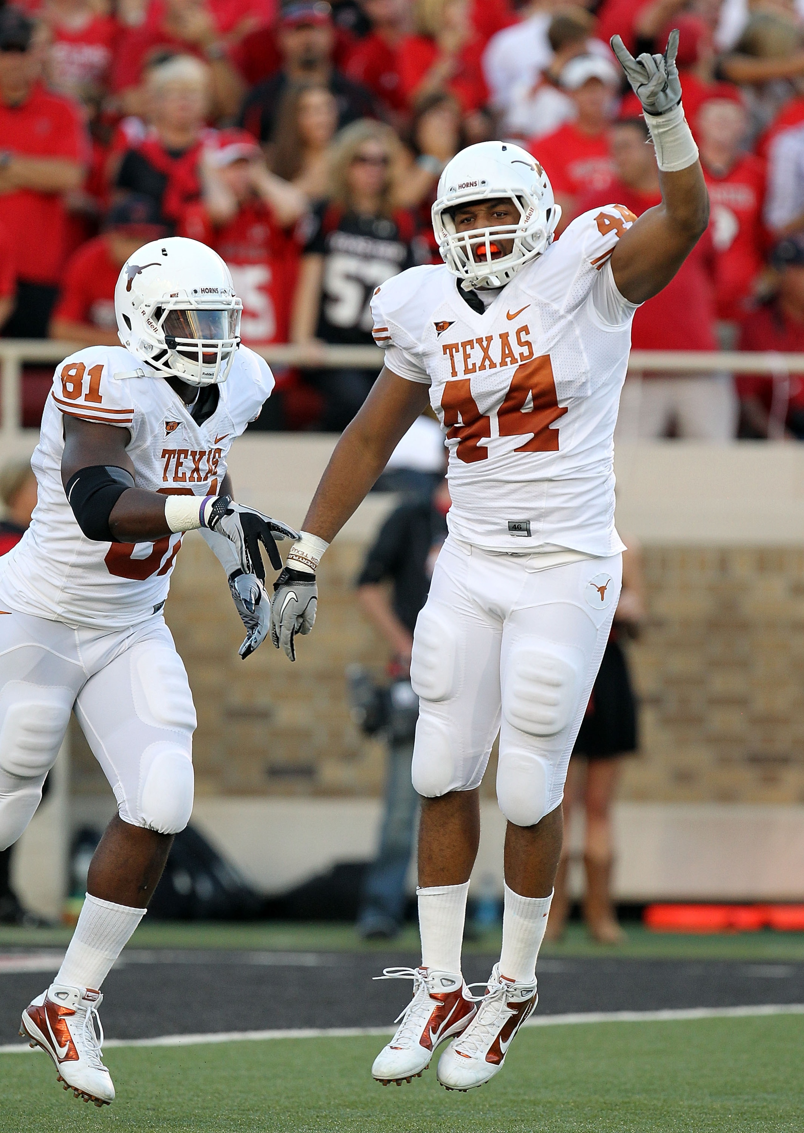 LUBBOCK, TX - SEPTEMBER 18: Jackson Jeffcoat #44 of the Texas Longhorns celebrates a fumble recovery with Sam Acho #81 in the first quarter against the Texas Tech Red Raiders at Jones AT&T Stadium on September 18, 2010 in Lubbock, Texas. (Photo by Ronal LUBBOCK, TX - SEPTEMBER 18: Jackson Jeffcoat #44 of the Texas Longhorns celebrates a fumble recovery with Sam Acho #81 in the first quarter against the Texas Tech Red Raiders at Jones AT&T Stadium on September 18, 2010 in Lubbock, Texas. (Photo by Ronal