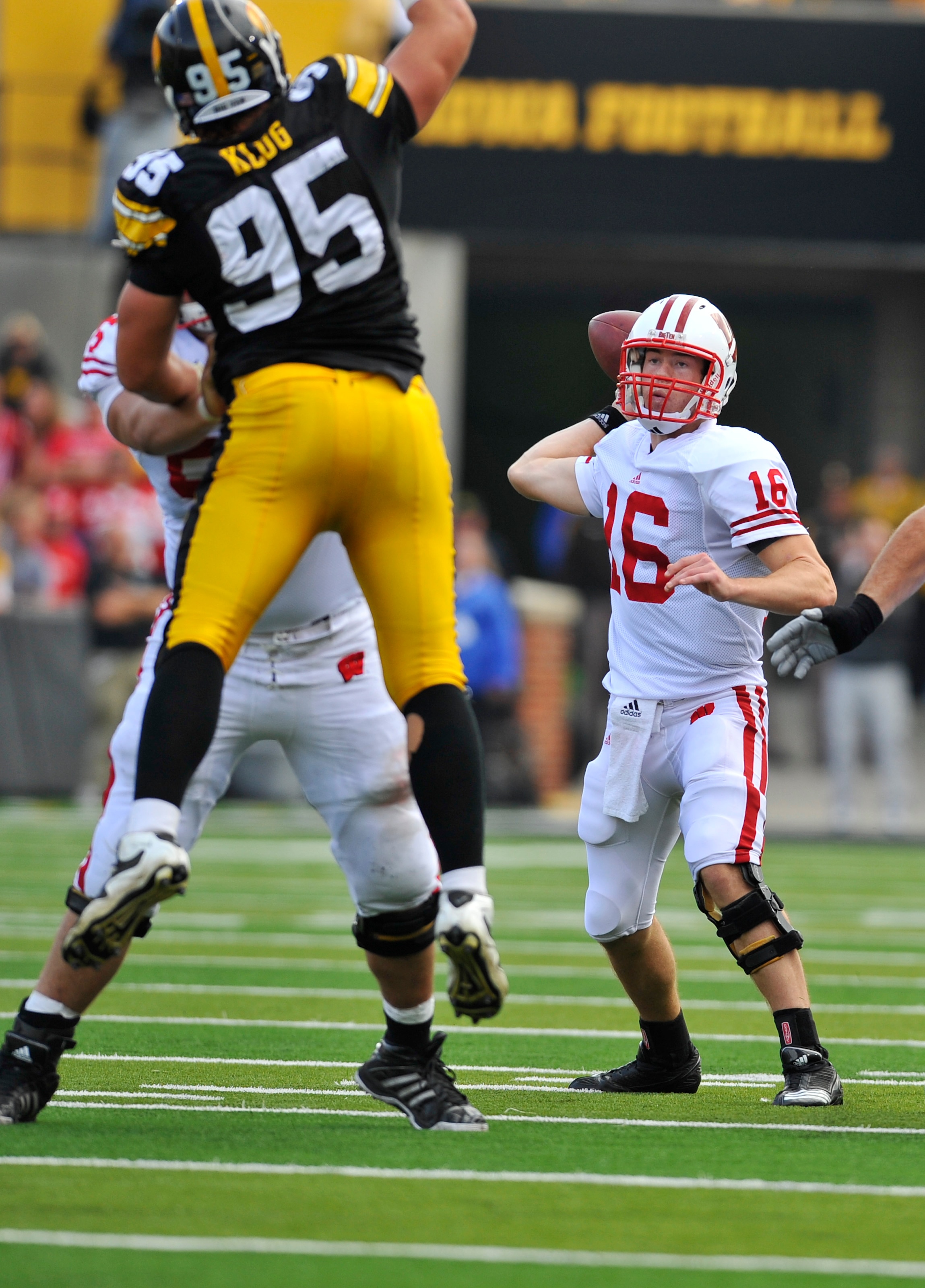 IOWA CITY, IA - OCTOBER 23: Quarterback Scott Tolzien #16 of the Wisconsin Badgers throws under pressure from Defensive lineman Karl Klug #95 of the University of Iowa Hawkeyes during the first half of play at Kinnick Stadium on October 23, 2010 in Iowa C